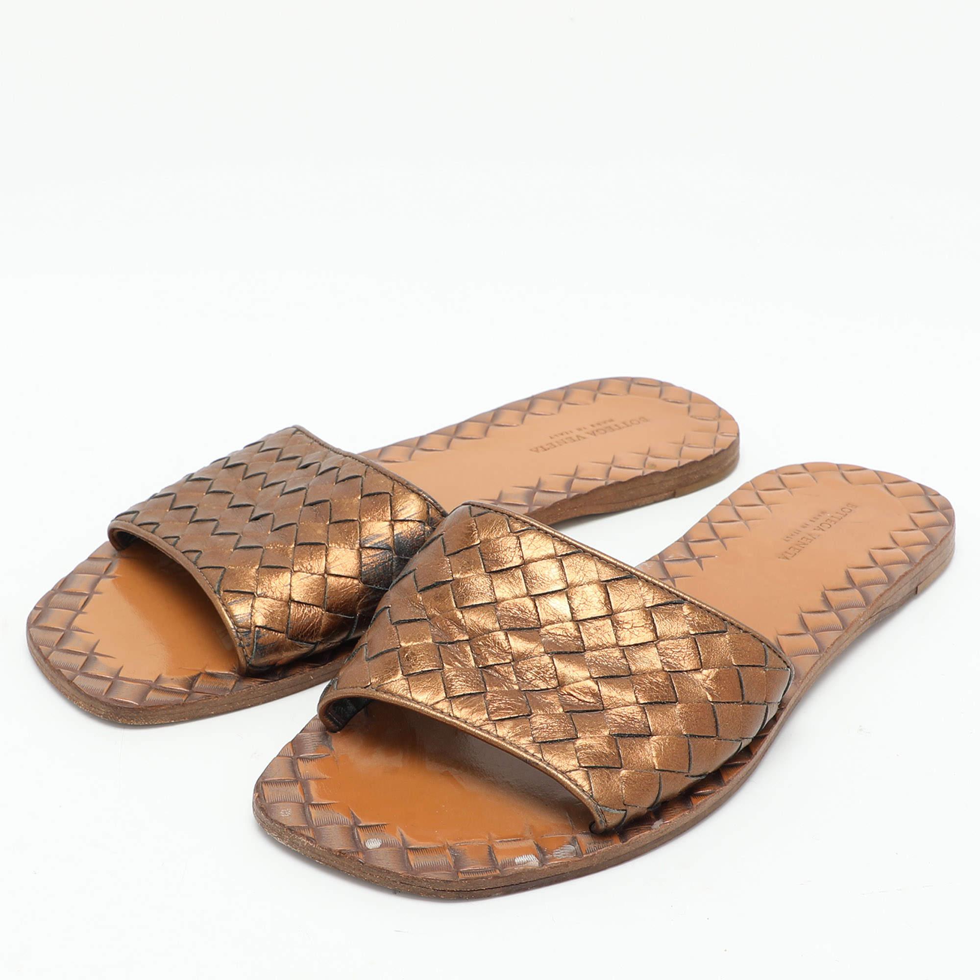 Crafted from leather these gold slides from Bottega Veneta feature the brands signature Intrecciato weave on the upper strap. This is definitely one pair that speaks style in a luxe way.