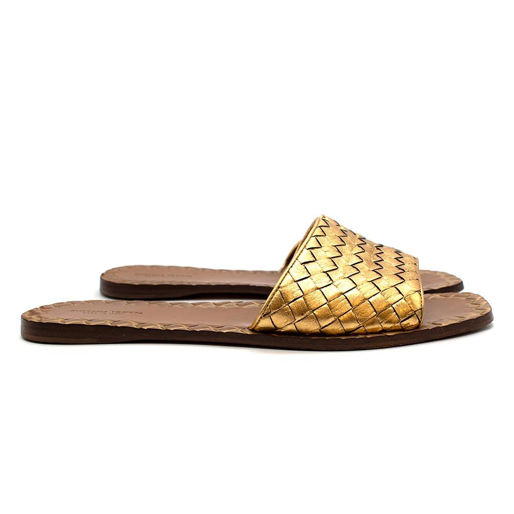 Bottega Veneta Gold Leather Intrecciato Flat Sandals

- Flat slides made of the iconic Intrecciato leather 
- Gold hue 
- Squared toes 
- Soft leather lining 
- Textured insole trims 
- Timeless elegant design 
- Perfect for the warm days ahead