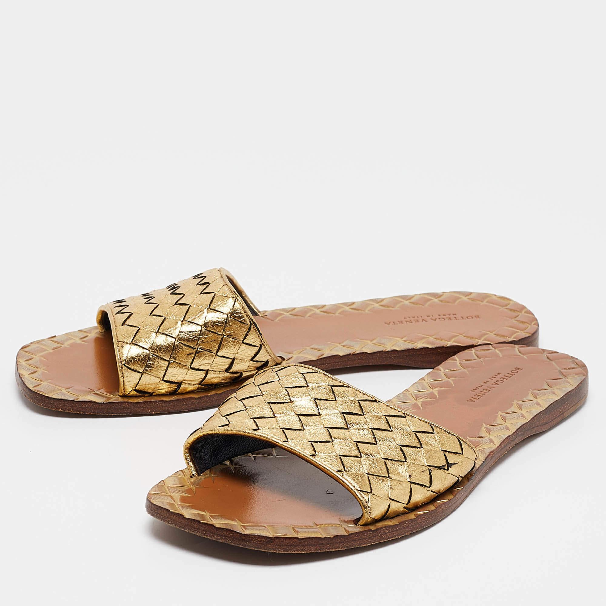 Put your best foot forward in these gold slides from Bottega Veneta. Theyve been crafted from leather and feature a strap across the vamp that boasts of the brands signature Intrecciato weave. The footbed is also styled with touches of the famous