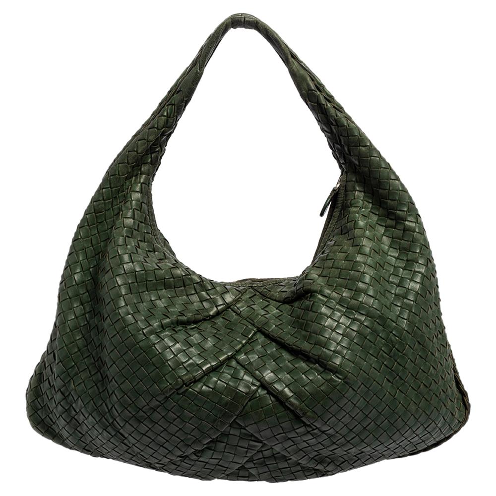 The excellent craftsmanship of this Bottega Veneta hobo ensures a brilliant finish and a rich appeal. Woven from leather in their signature Intrecciato pattern, the green-hued bag is provided with minimal silver-tone hardware. It features a loop