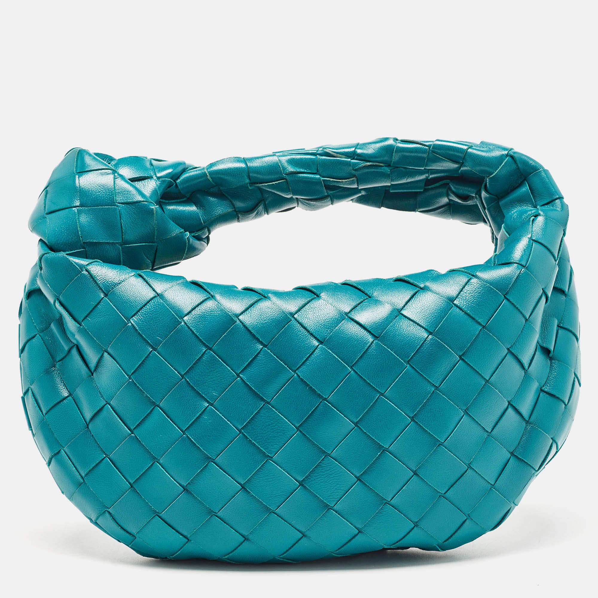 This Bottega Veneta mini Jodie bag is crafted from leather using their signature Intrecciato weaving technique, flaunting a seamless silhouette. This bag, personifying elegance and subtle charm, is held by a knotted handle. Brimming with artistry