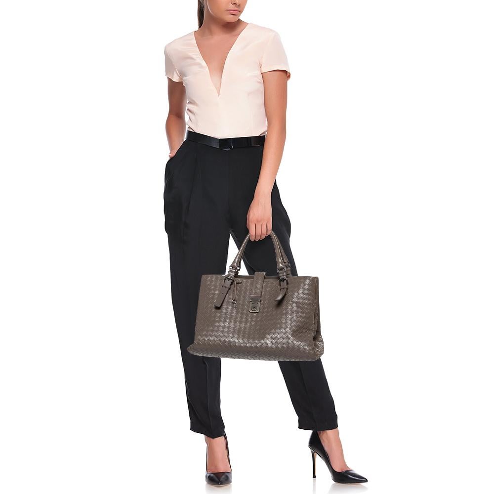 This Bottega Veneta Roma tote is a creation that brings joy to one's sight! It has been beautifully crafted from leather and designed in their signature Intrecciato pattern while being held by two top handles. The bag is also equipped with a flap