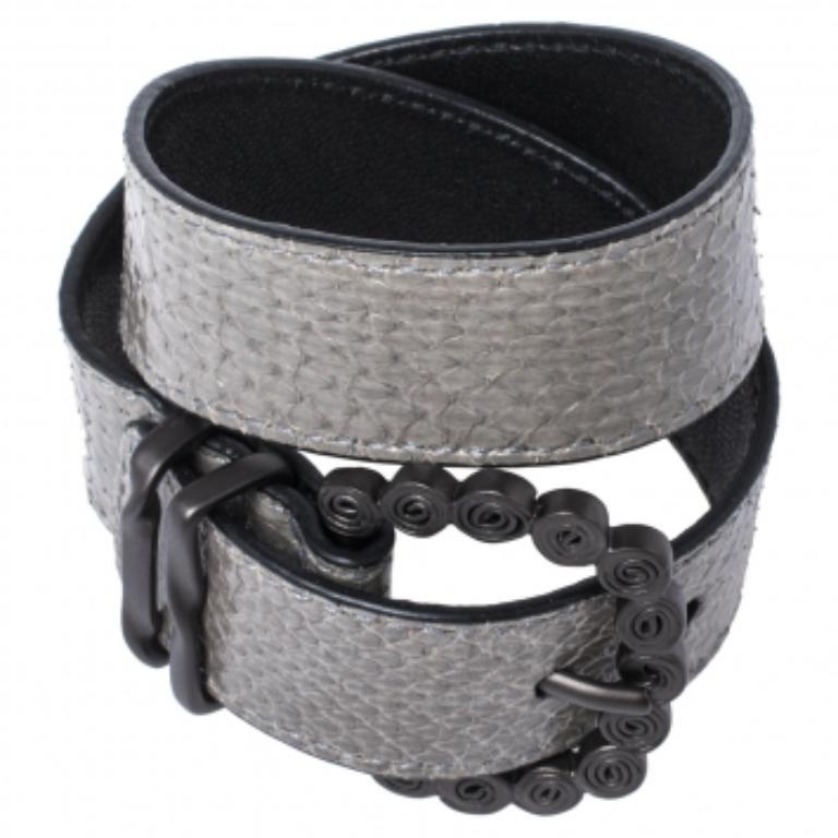 Accessorize in a whole new way with this double wrap bracelet from Bottega Veneta  It is crafted from snakeskin and leather and enhanced with a gunmetal-tone stylish buckle. NOTE: (Available for UAE Customers Only).

