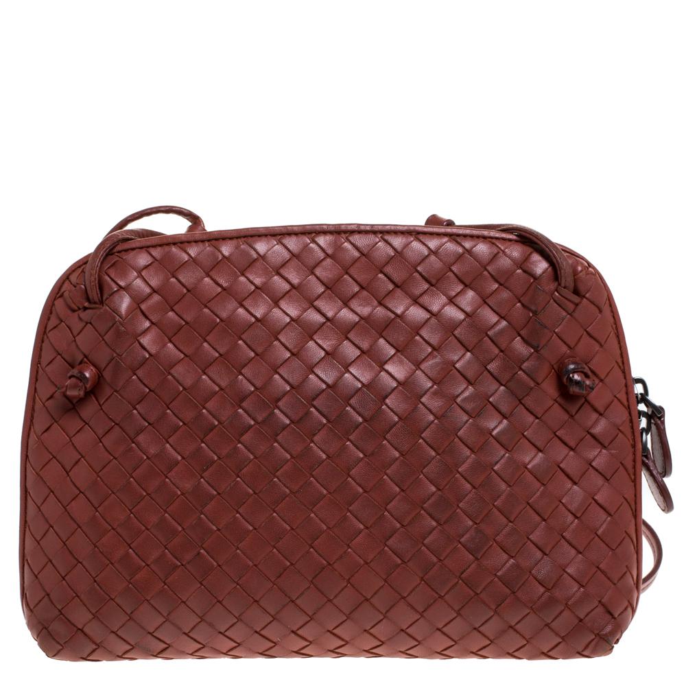 This Nodini bag from Bottega Veneta is crafted from brown leather using their signature Intrecciato weaving technique flaunting a seamless silhouette. This shoulder bag, personifying elegance and subtle charm, is held by a long shoulder strap.