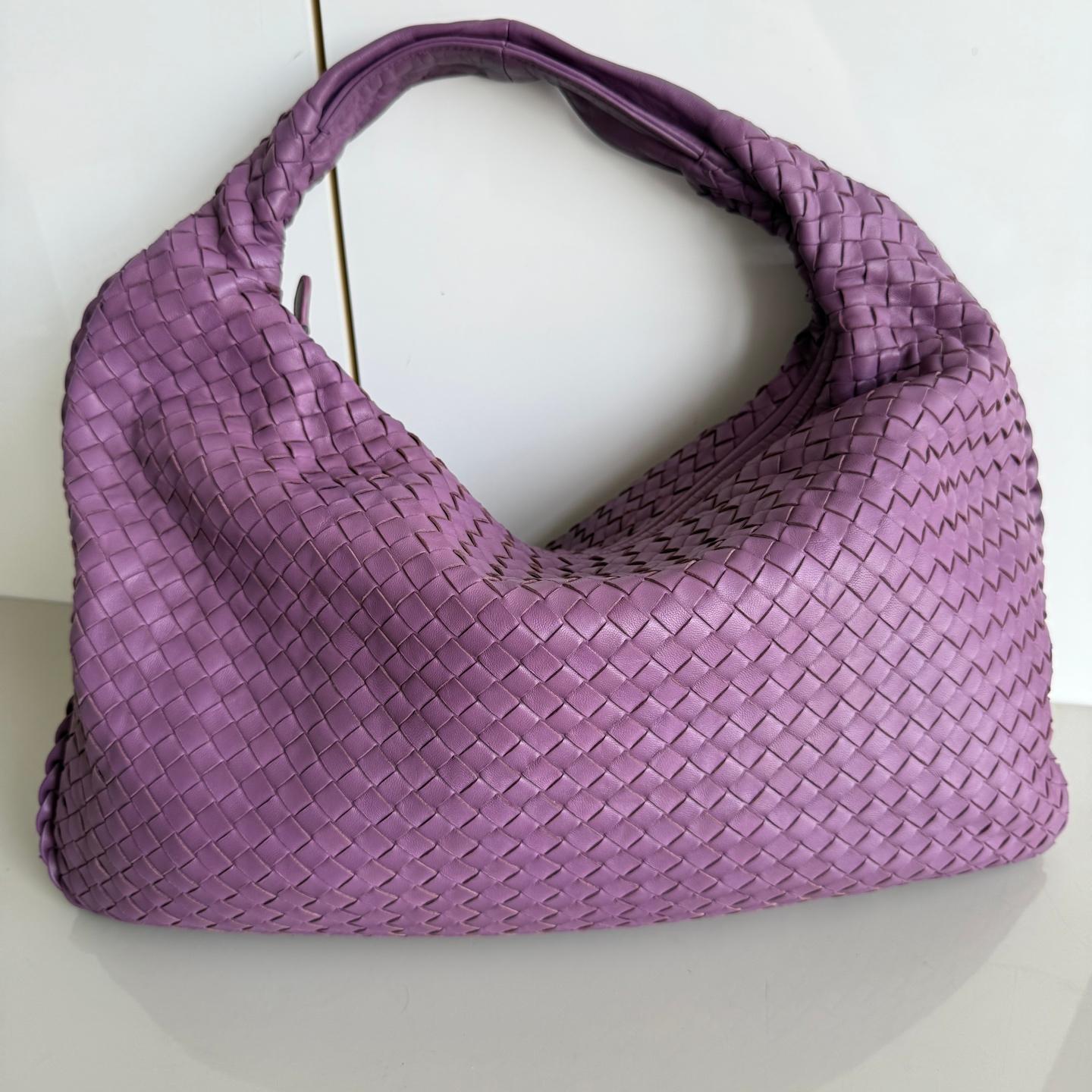 Experimenta el lujo supremo con este Bolso Hobo Grande de Bottega Veneta en rica piel de cordero rojo burdeos. Con el emblemático tejido Intrecciato y 51 cm de ancho en la base, este bolso ofrece un amplio espacio para todos tus objetos esenciales.