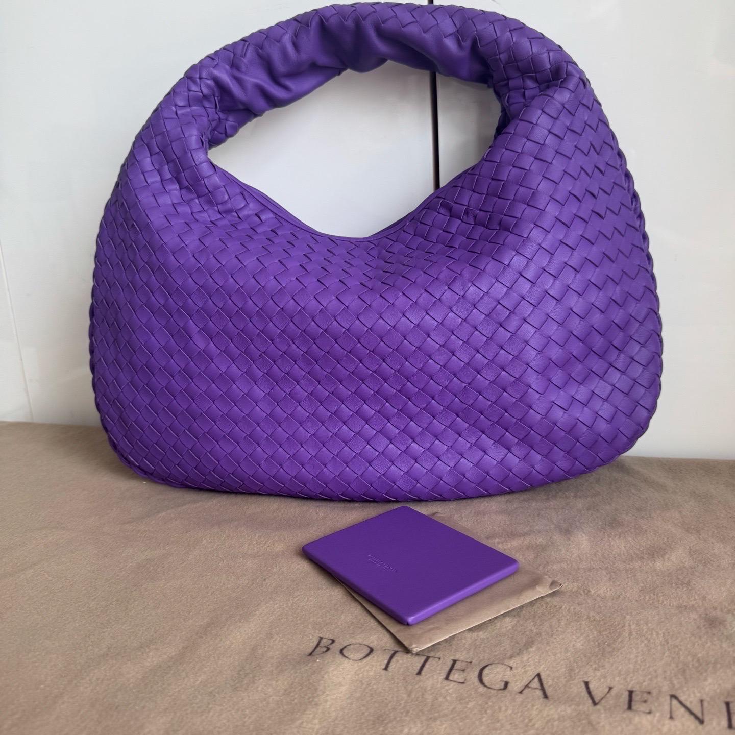 Experience ultimate luxury with this Bottega Veneta Hobo Bag Large in rich burgundy red lambskin leather. Featuring the iconic Intrecciato weave and measuring 51cm wide at the base, this bag offers ample space for all your essentials. Perfect for