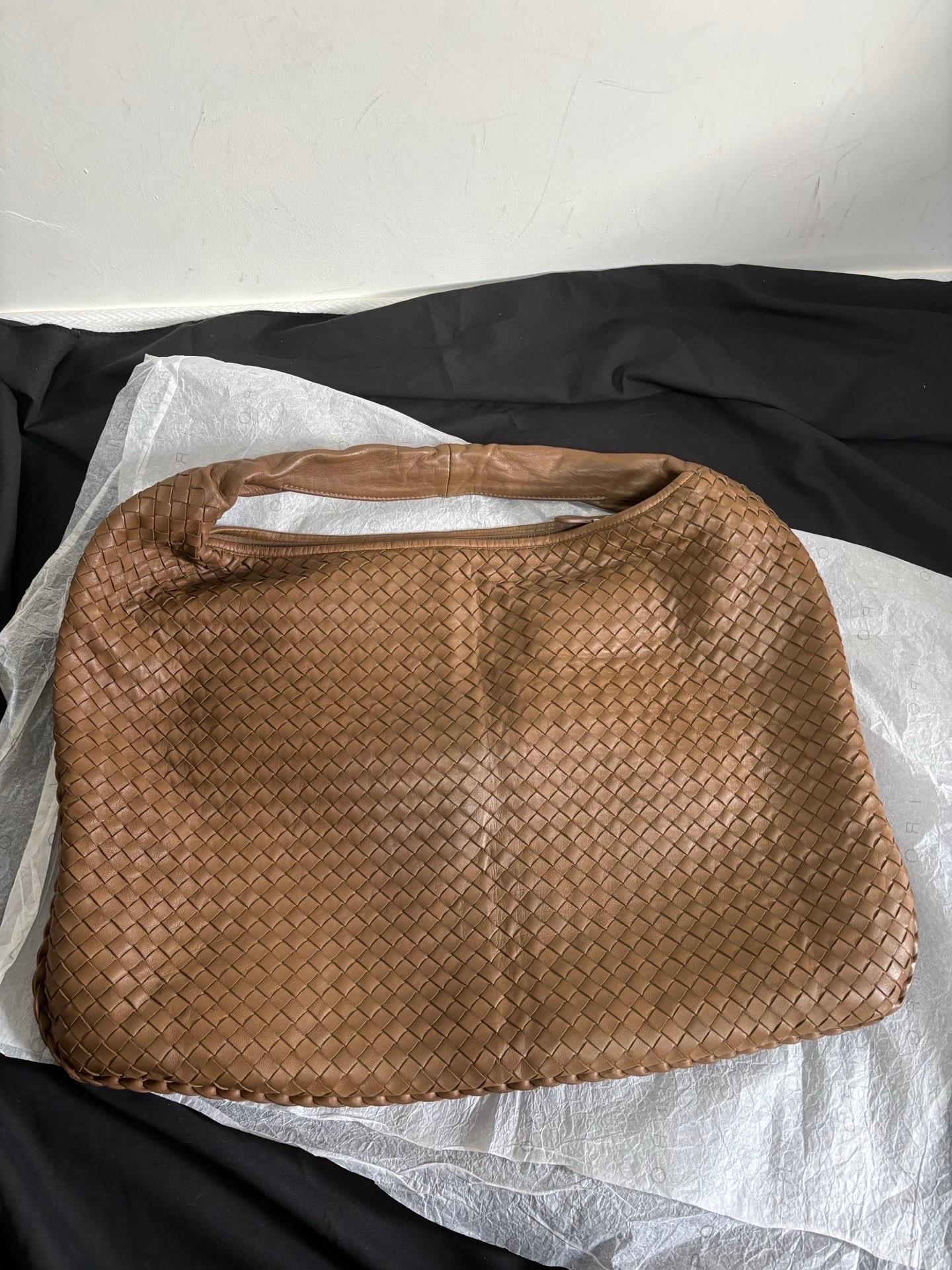 Prova il lusso estremo con questa Hobo Bag Large di Bottega Veneta in pelle di agnello color cioccolato. Caratterizzata dall'iconica trama Intrecciato e larga 51 cm alla base, questa borsa offre ampio spazio per tutti i tuoi oggetti essenziali.