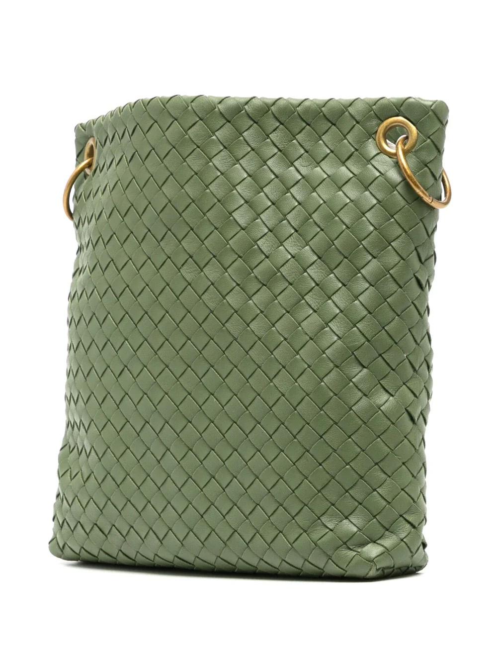 The Intrecciato Crossbody Bag is crafted from premium pistachio green leather, with signature Intrecciato weaved detailing and gold-tone hardware. It has an adjustable shoulder strap and a spacious main compartment that make it a perfect crossbody