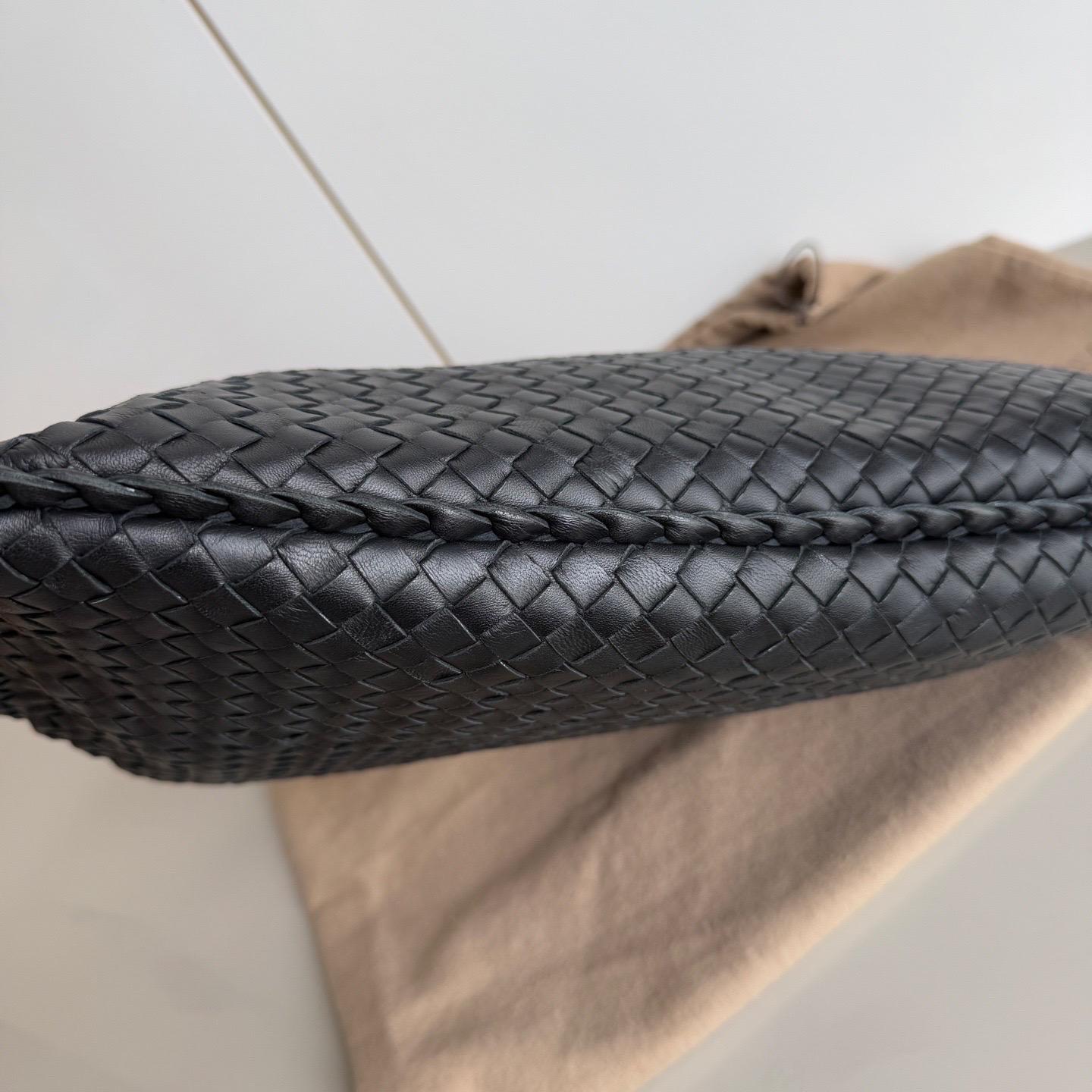 Ce sac hobo Bottega Veneta est une pièce de luxe exceptionnelle, réalisée en cuir d'agneau noir emblématique avec le tissage Intrecciato immédiatement reconnaissable. Suffisamment spacieux pour contenir tous vos essentiels, c'est l'accessoire