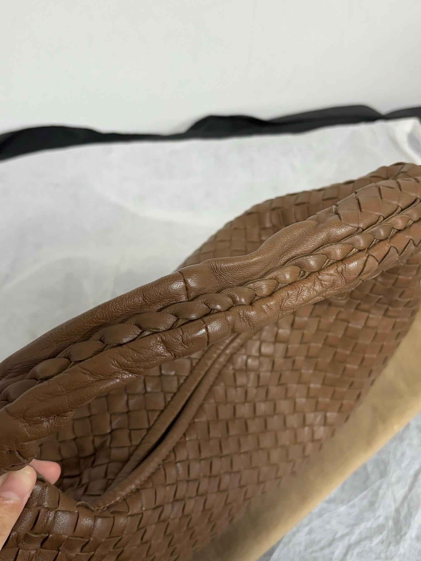 Ce sac hobo Bottega Veneta est une pièce de luxe exceptionnelle, réalisée en cuir d'agneau marron emblématique avec le tissage Intrecciato immédiatement reconnaissable. Suffisamment spacieux pour contenir tous vos essentiels, c'est l'accessoire