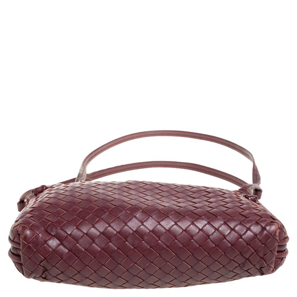 One look at this Nodini bag from Bottega Veneta and you'll be awed by its high style and magnificent appeal. It is crafted from burgundy leather using their signature Intrecciato weaving technique flaunting a seamless silhouette and sturdy