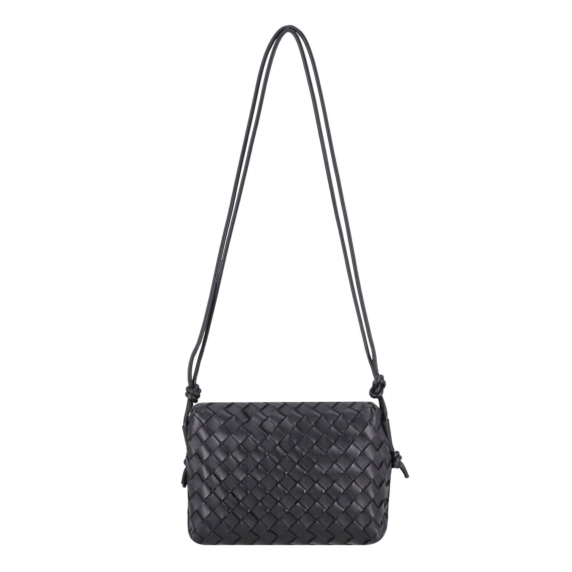 Bottega Veneta Intrecciato Leder Kleine Loop Crossbody Tasche

Schwarze Tasche aus gewebtem Intrecciato-Lammfell in kompakter, kastenförmiger Form mit einem charakteristischen, geknoteten Riemen.

Mit goldenem Reißverschluss oben, der zu einem