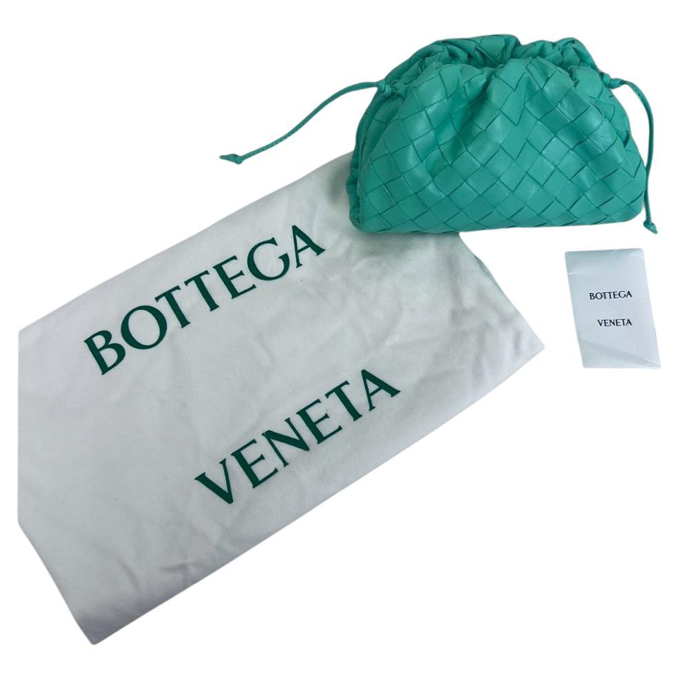Un tocco audace su una silhouette molto amata: questo Mini Pouch di Bottega Veneta è realizzato con l'iconica pelle d'agnello Intrecciato della maison in una sorprendente tonalità verde. La forma compatta, simile a una nuvola, è morbidamente