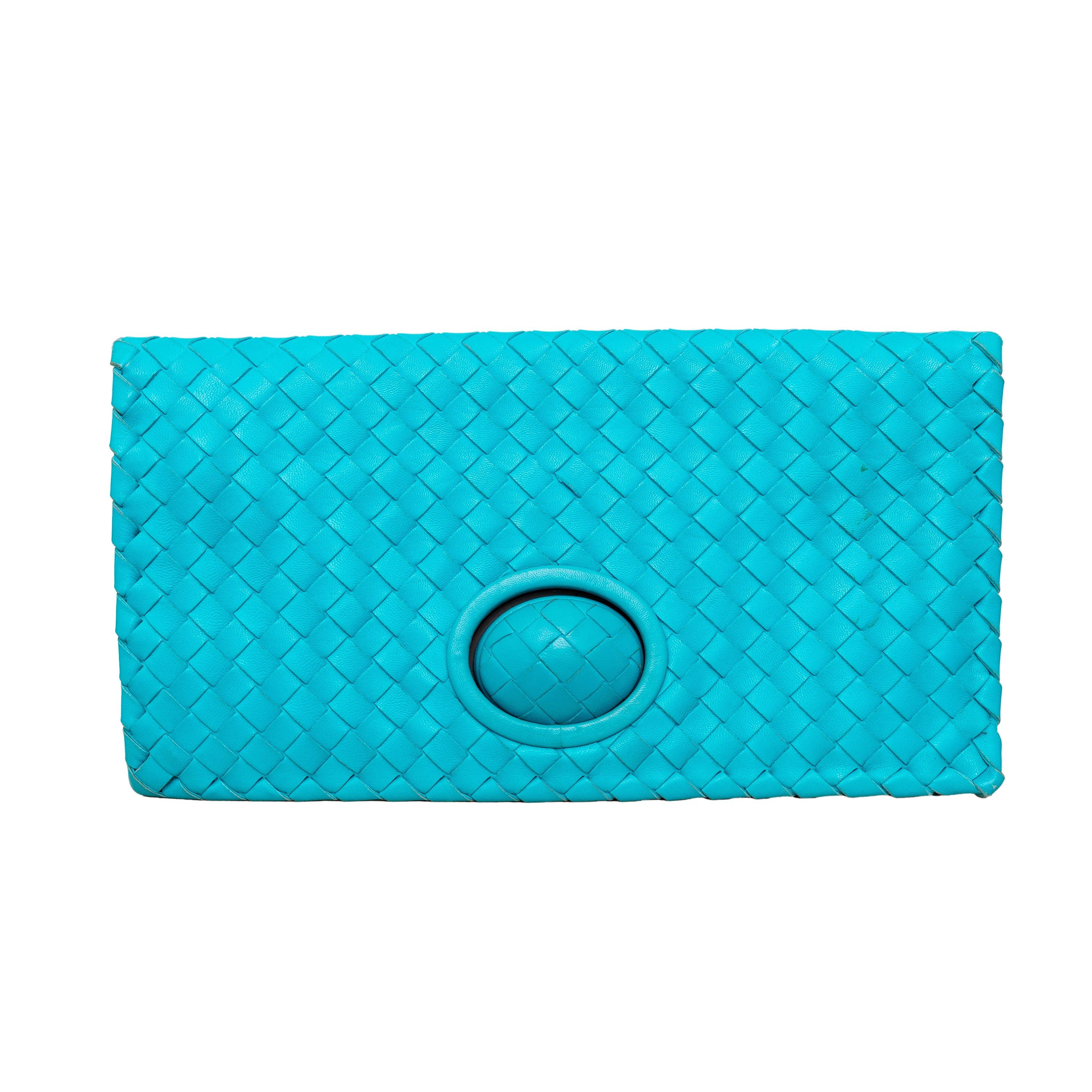 Cette pochette Bottega Veneta arbore la signature du cuir Intrecciato dans un bleu turquoise époustouflant. Sa quincaillerie en bronze ajoute une touche de sophistication, tandis que les deux compartiments intérieurs, dont l'un est doté d'une