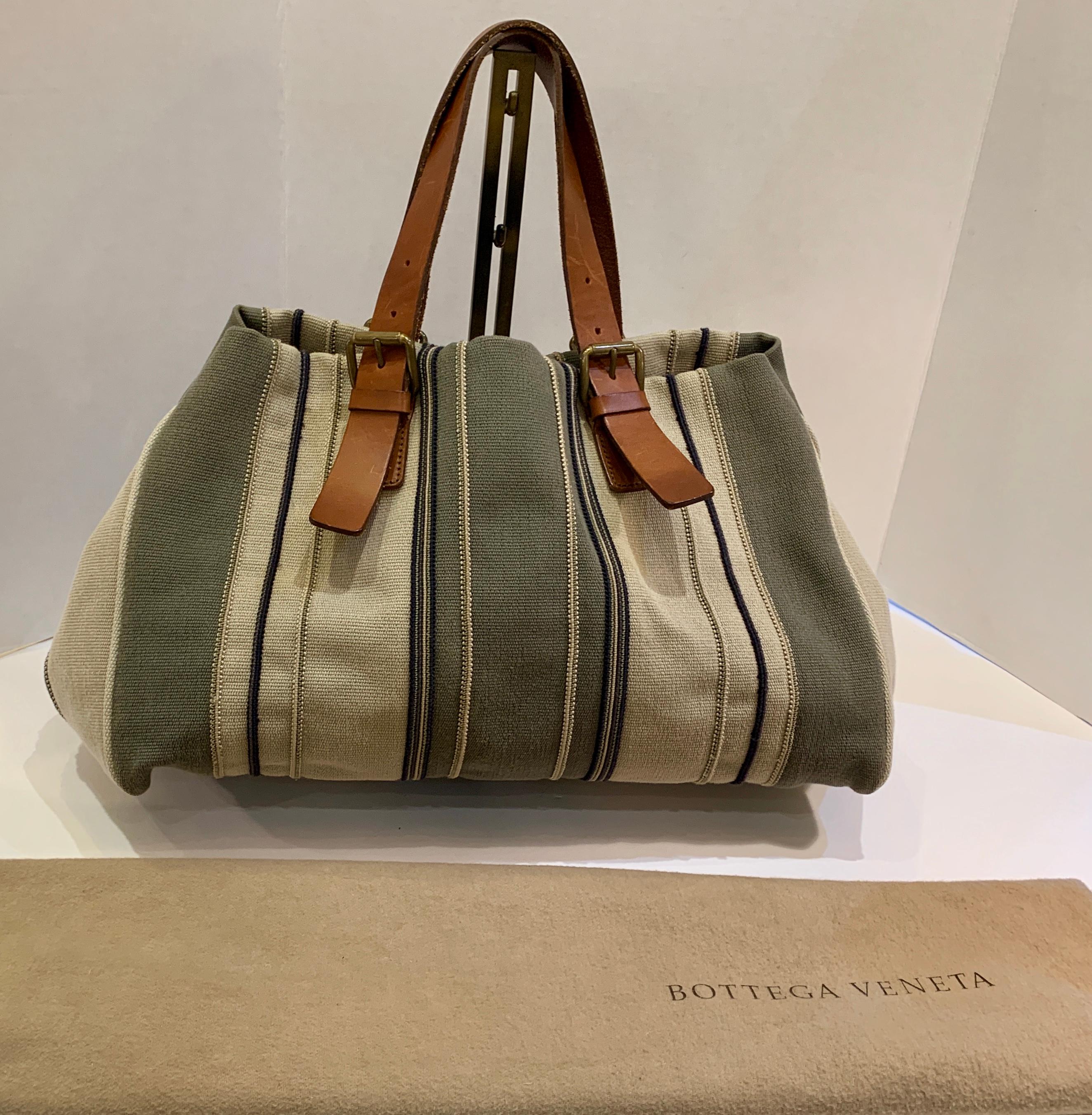 Bottega Veneta values quality craftsmanship, exclusivity and discreet luxury in the creation of its timeless handbags. This spacious, multi-colored, earth-toned striped canvas handbag or satchel features adjustable saddle colored distressed leather