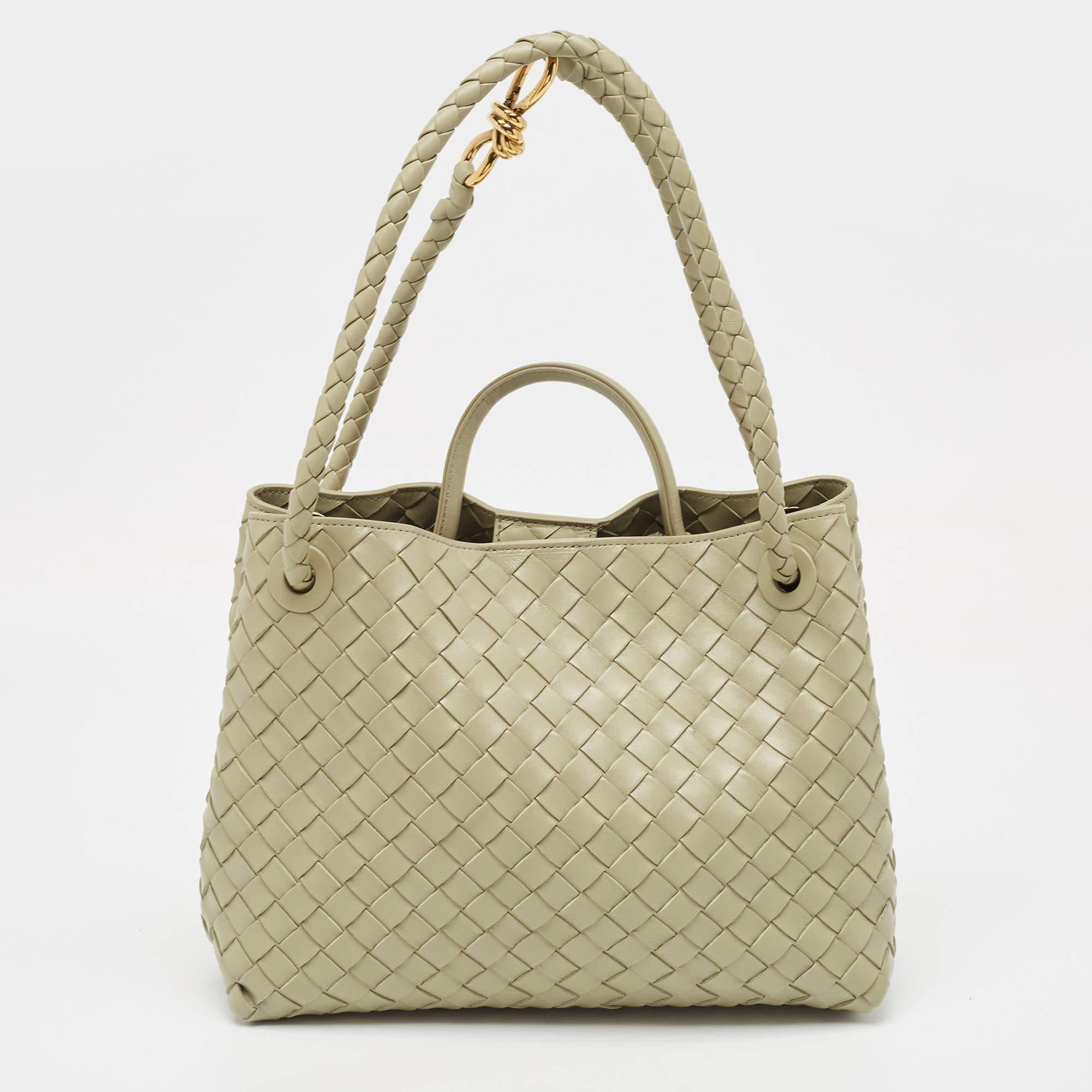 Crafted with precision and sophistication, the Bottega Veneta Andiamo bag is the epitome of timeless elegance. Its supple leather, meticulously woven in the iconic Intrecciato pattern, exudes luxury. With a spacious interior and chic top handle, it
