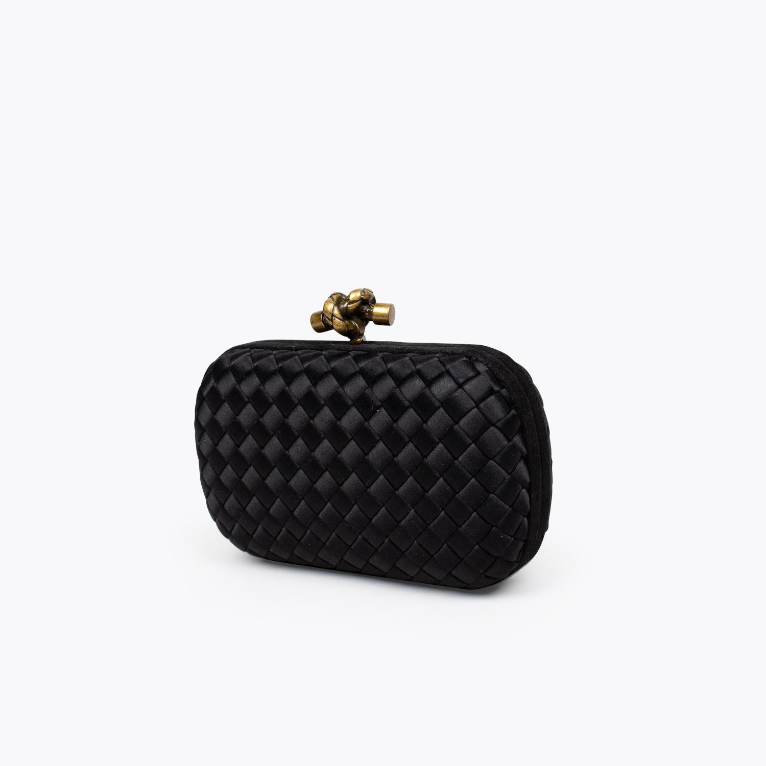 Black Intrecciato satin Bottega Veneta Knot clutch with

– Gold-antique tone hardware
– Tonal satin lining and push-lock closure at top.

Overall Preloved Condition: Very Good
Exterior Condition: Very Good. Minor surface scratches and marks