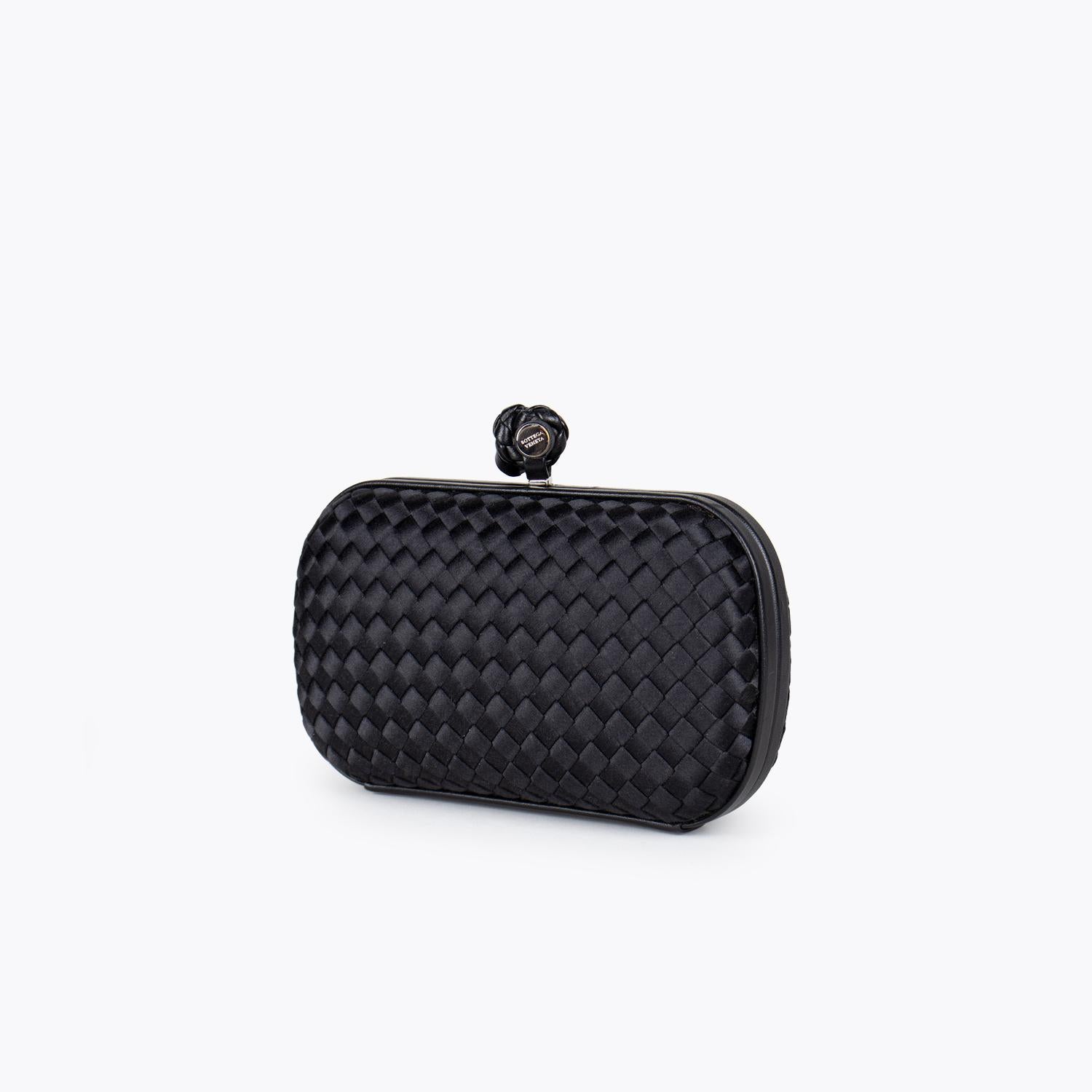 Black Intrecciato satin Bottega Veneta Knot clutch with

– Silver tone hardware
– Tonal satin lining and push-lock closure at top

Overall Preloved Condition: Very Good
Exterior Condition: Very Good. Minor surface scratches and marks