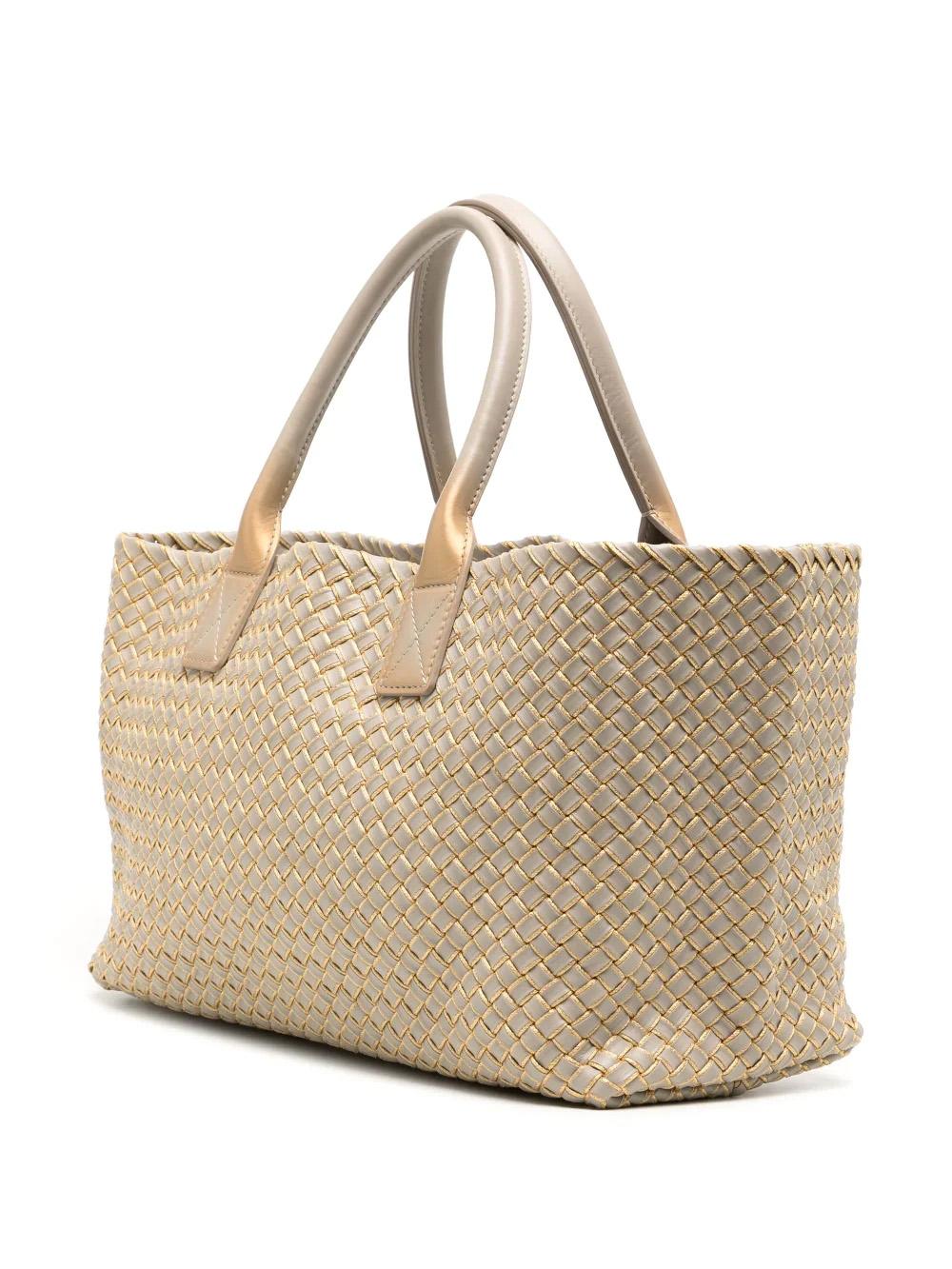 This luxurious tote bag is crafted from Intrecciato leather with Bottega's signature weaving design. It features a single detachable interior pocket with card slots, two rolled-top handles, and an open top. An ideal balance of light grey and