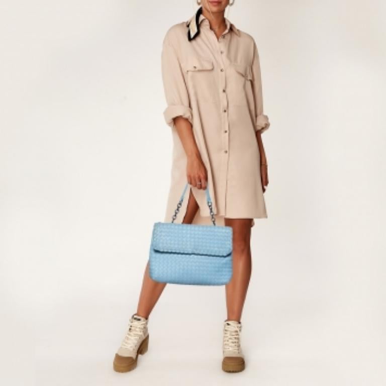 Bottega Veneta's Olimpia bag presents the label's artistry in fine craftsmanship and classic designs. Woven in their Intrecciato technique, it features a light blue shade, a single handle, and a front flap that opens to reveal a well-sized interior