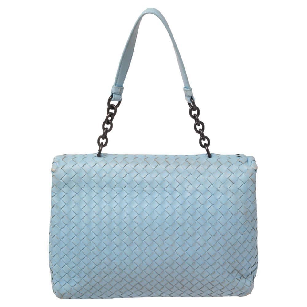 Bottega Veneta's Olimpia bag presents the label's artistry in fine craftsmanship and classic designs. Woven in their Intrecciato technique, it features a light blue shade, a single handle, and a front flap that opens to reveal a well-sized interior