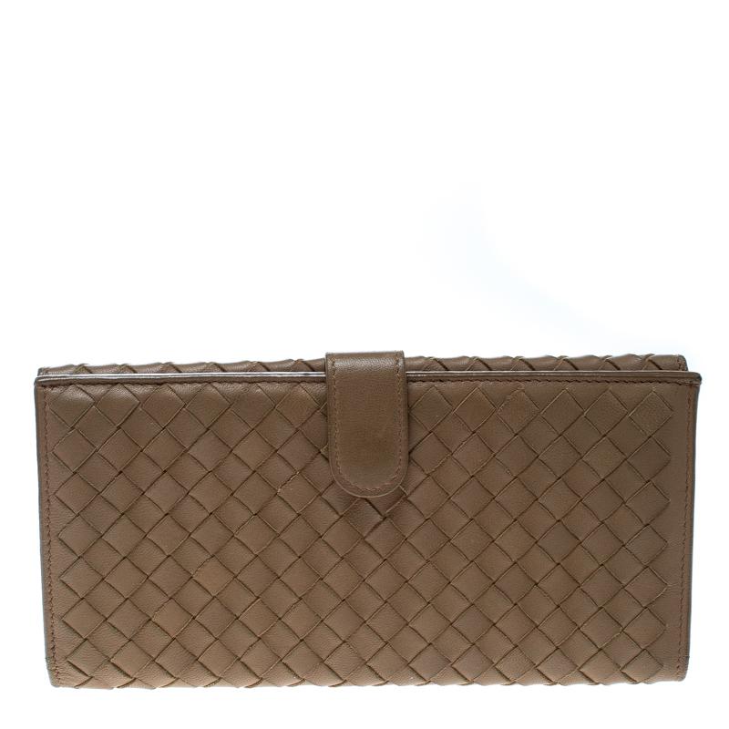 This Bottega Veneta wallet is conveniently designed for everyday use. Crafted from leather the piece has a lovely light brown color and a leather and fabric lined interior. The interior houses multiple card slots and open compartments for you to