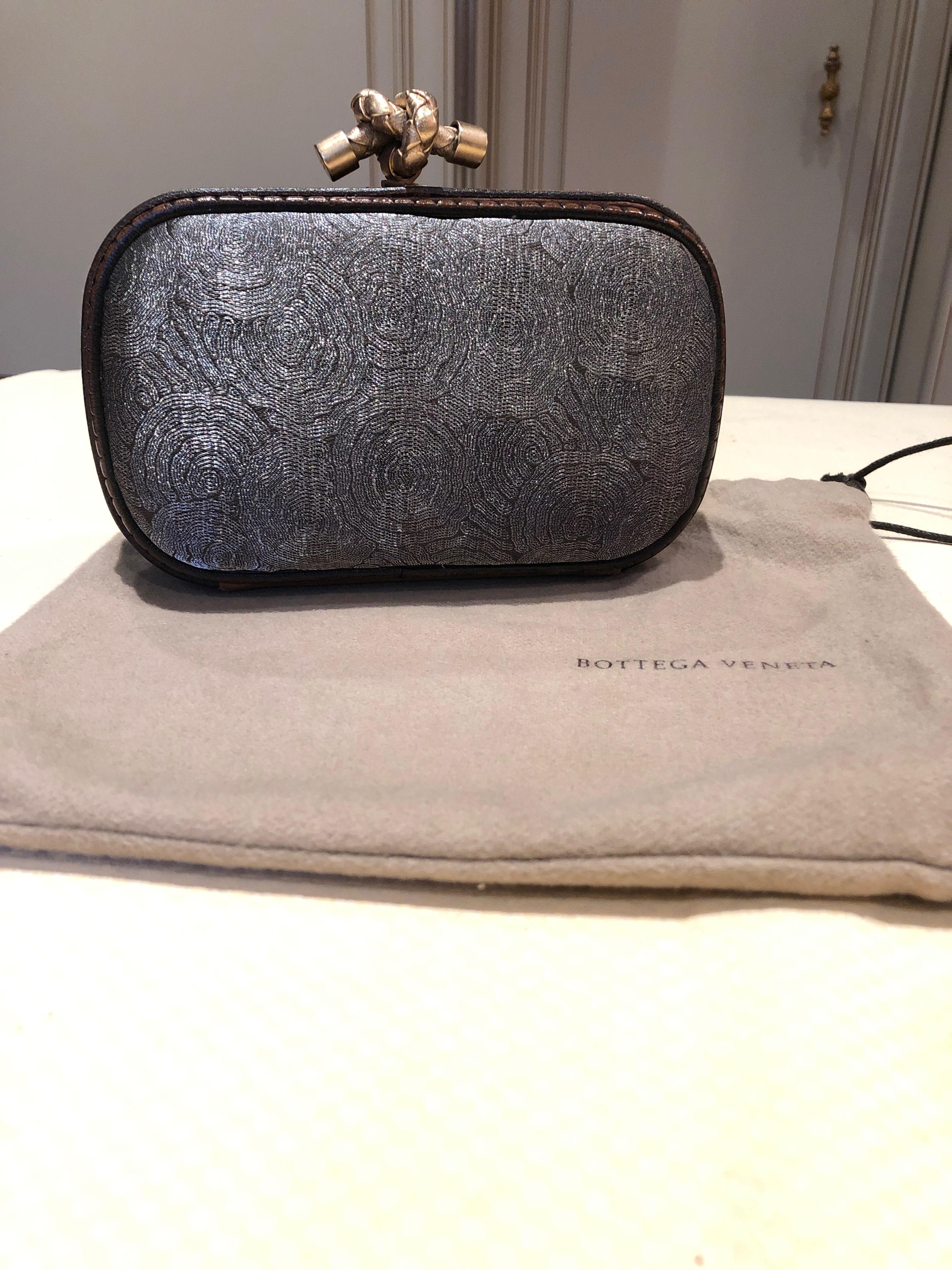 A supremely elegant clutch purse by Bottega Veneta, Limited Edition, with grey metal threads and luxurious brass knot to open and close. Lined in buttery leather. All the best materials and workmanship. A jewel. Maybe used once.
 
