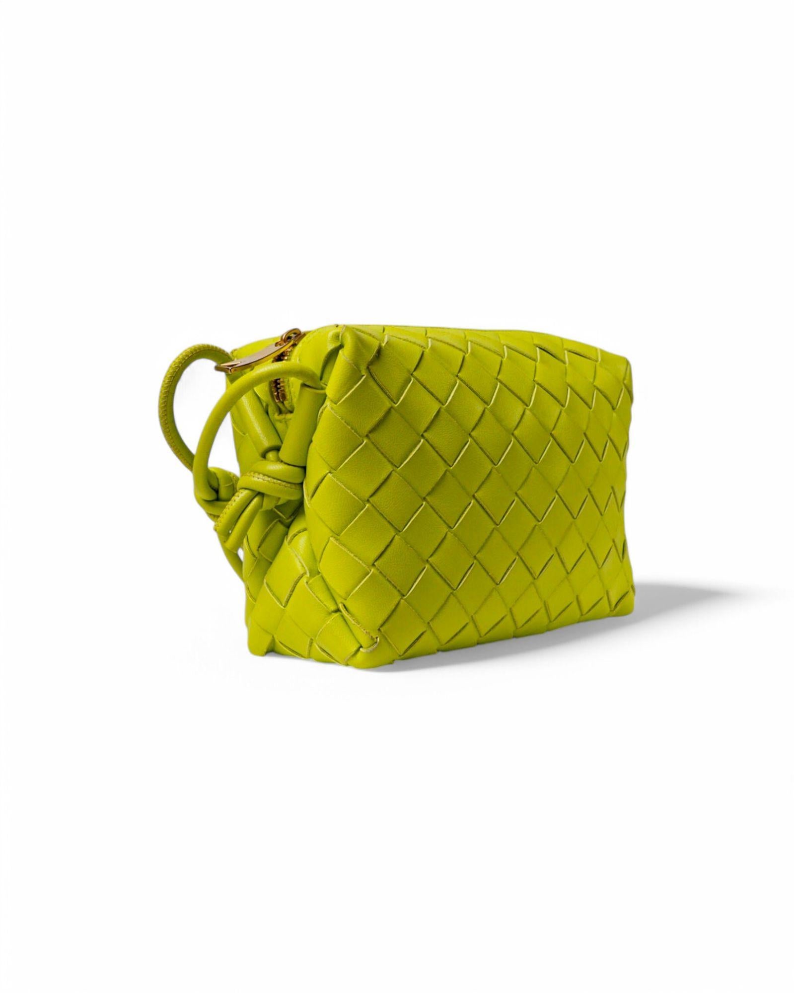 Bottega Veneta signature bag, Loop model in the mini size, made of woven leather in the refined Acid Kiwi color with gold hardware details. Featuring a top zipper closure, the interior is lined in tone-on-tone suede fabric, perfect for holding the