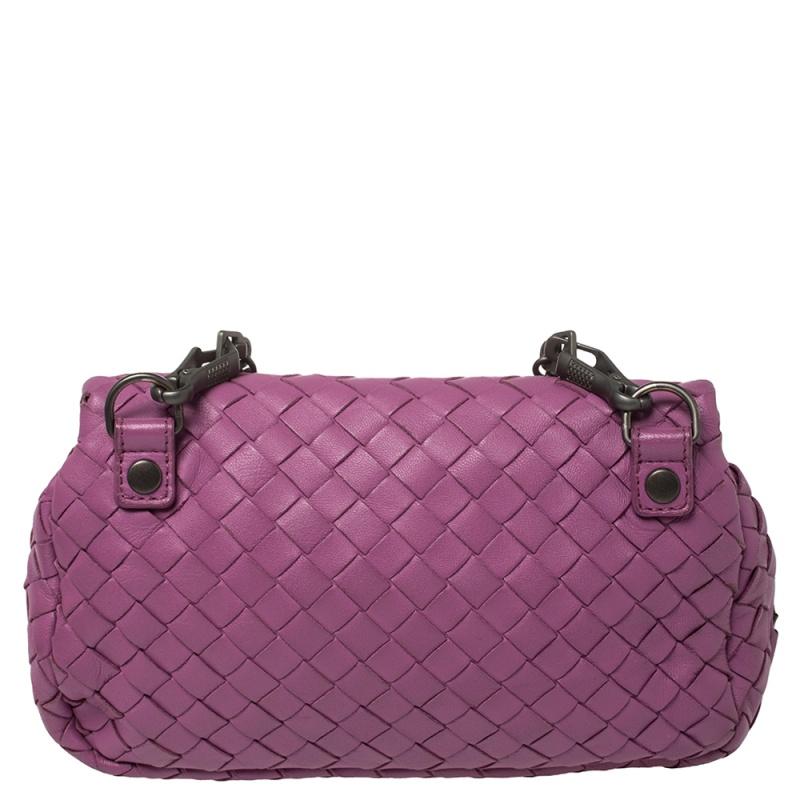 The excellent craftsmanship of this Bottega Veneta bag ensures a brilliant finish and a rich appeal. Woven from leather in their signature Intrecciato pattern, the magenta-hued bag is provided with minimal black-tone hardware. It features a chain
