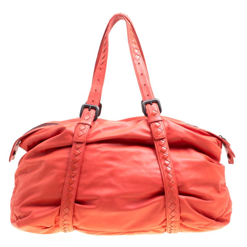 Exuding a cool, laidback vibe, this bag from Bottega Veneta in a lovely carrot orange hue will make you forget all the other bags you have seen or liked. It is spacious and durable and is crafted from leather. The twin top handles encircle the bag