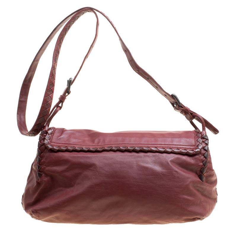 Flaunt your exclusive taste of fashion with this messenger bag from Bottega Veneta. Lovely in maroon, this Karung bag is crafted from leather and features the brand's signature Intrecciato pattern detailing on the edges. It flaunts an adjustable