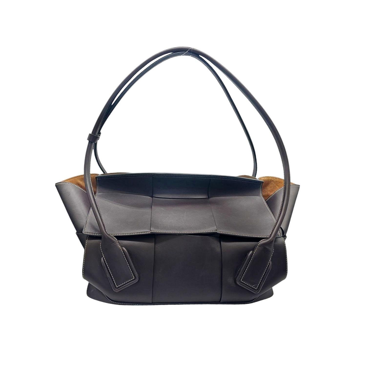 Confeccionado en lujosa piel de becerro de un intenso color marrón, el bolso Tote Bottega Veneta Maxi Intrecciato Arco 56 es a la vez elegante y práctico. Su maxi tejido ortogonal y sus pespuntes añaden detalles sofisticados, mientras que el panel