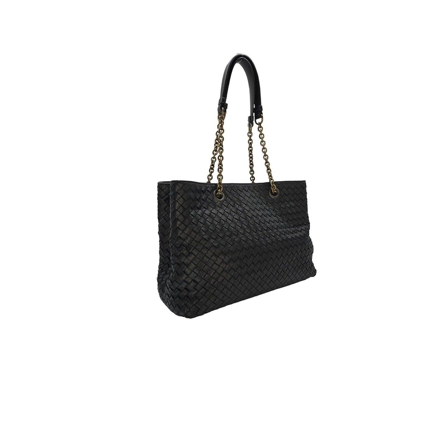 Indulge in the luxurious sophistication of this Bottega Veneta Intrecciato Chain Strap Tote. Expertly crafted from black woven leather, this tote exudes elegance and refinement. The matte black chain link shoulder straps with leather shoulder pads