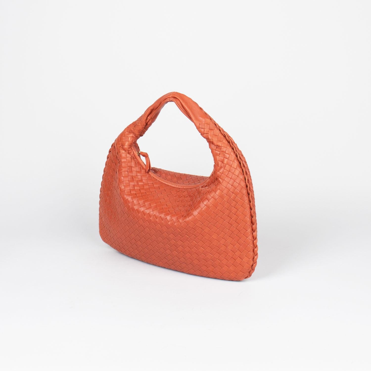 Orange Intrecciato leather Bottega Veneta Medium Hobo bag with

- Gold-tone hardware
- Single flat shoulder strap
- Tan suede lining
- Dual pockets at interior walls; one with zip closure and zip closure at top

Overall Preloved Condition: Very