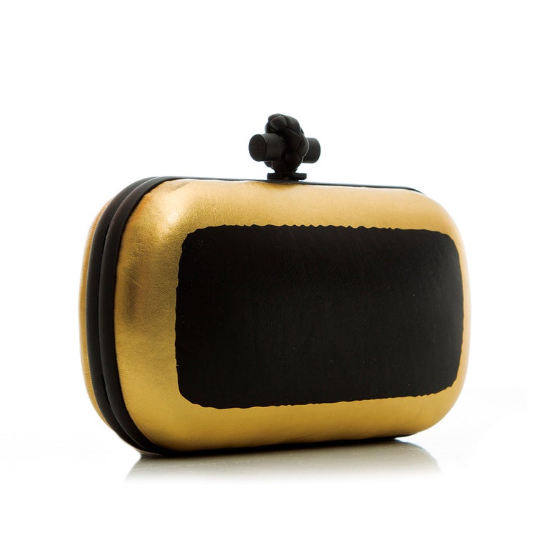 Crafted in Italy, Bottega Veneta meticulously reworked their iconic 'Intrecciato panel' Clutch bag with this opulent evening companion. Showcasing a bold, minimalistic, two-tone colour palette of shimmering gold and black lambskin leather, a