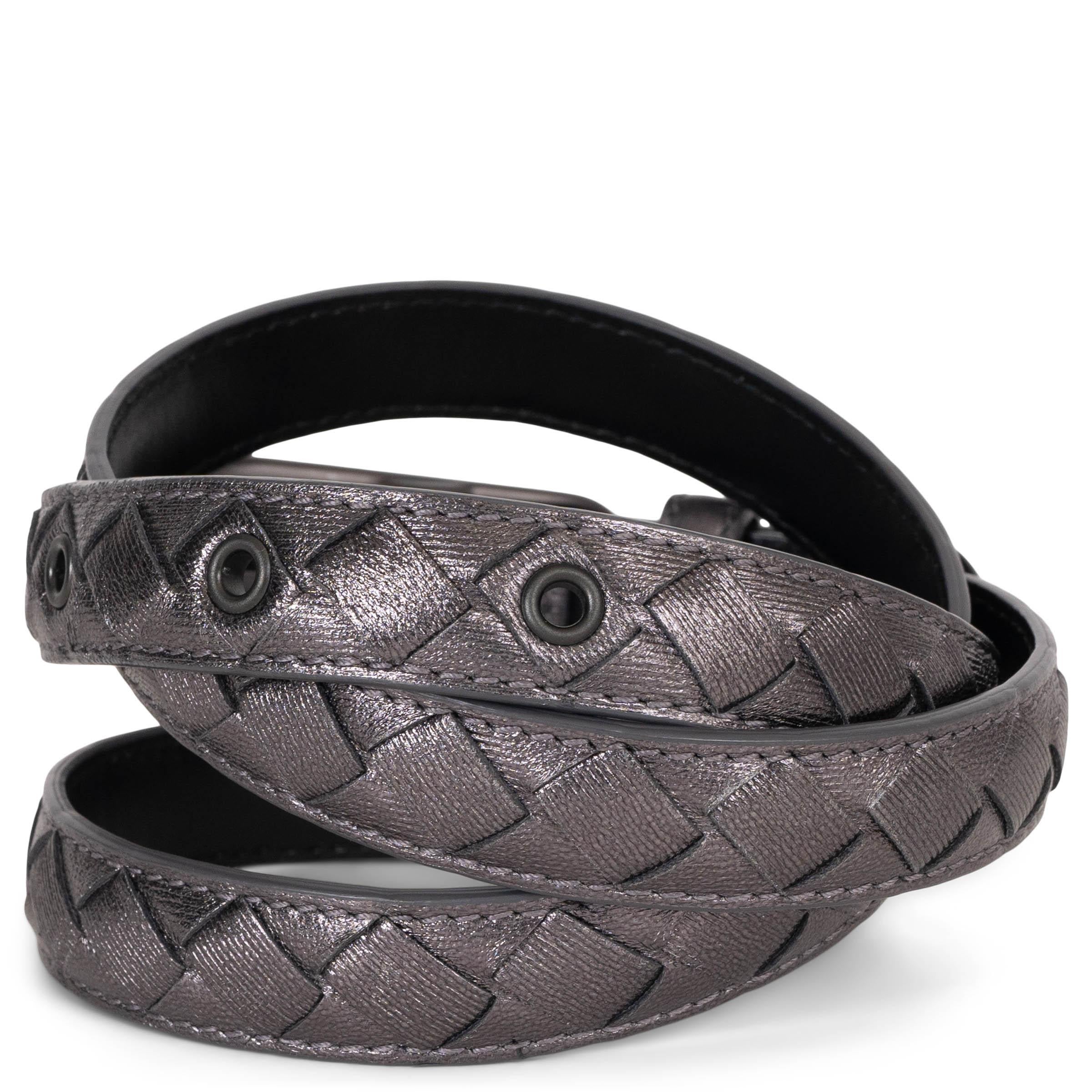 Este cinturón pitillo 100% auténtico de Bottega Veneta en piel Intrecciato de color peltre metalizado ofrece un toque elegante y moderno. Acabada con una hebilla redondeada en bronce mate y ojales a juego, aporta un acento refinado y contemporáneo a