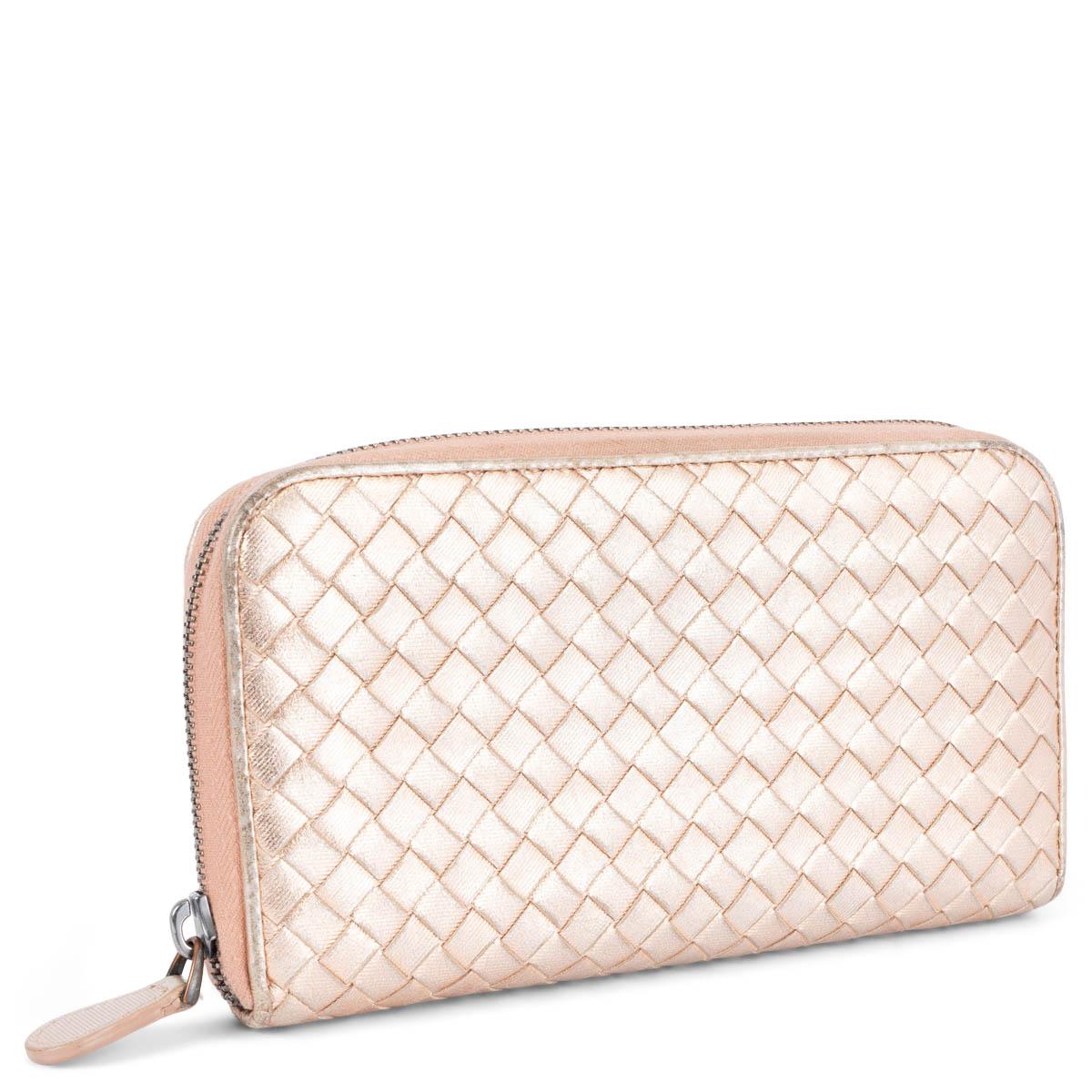 100% authentic Bottega Veneta Intrecciato zipper wallet metallic nude calfskin. Opens with a zipper to a nude and brown leather interior with eight credit card slots, two bill compartments, two extra compartments on the back and a zipped coin pocket