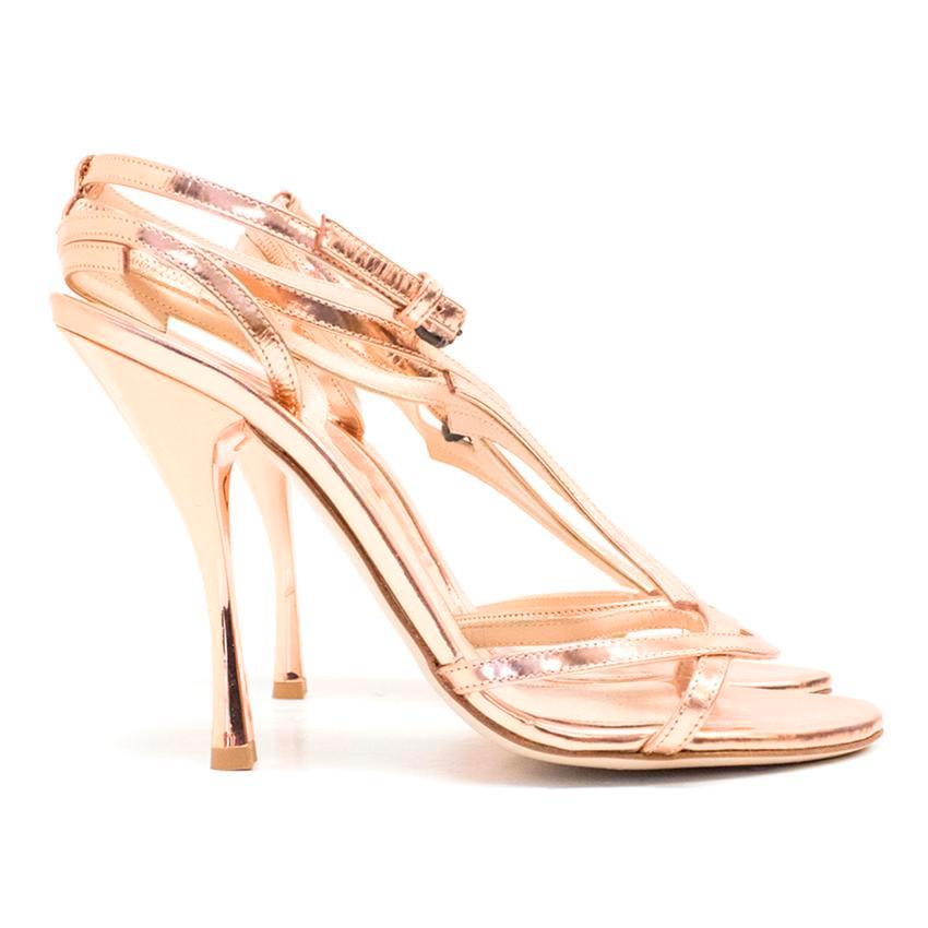 Bottega Veneta metallic rose gold open toe heels. 
Featuring cross over straps and stiletto heels.

Please note, these items are pre-owned and may show signs of being stored even when unworn and unused. This is reflected within the significantly