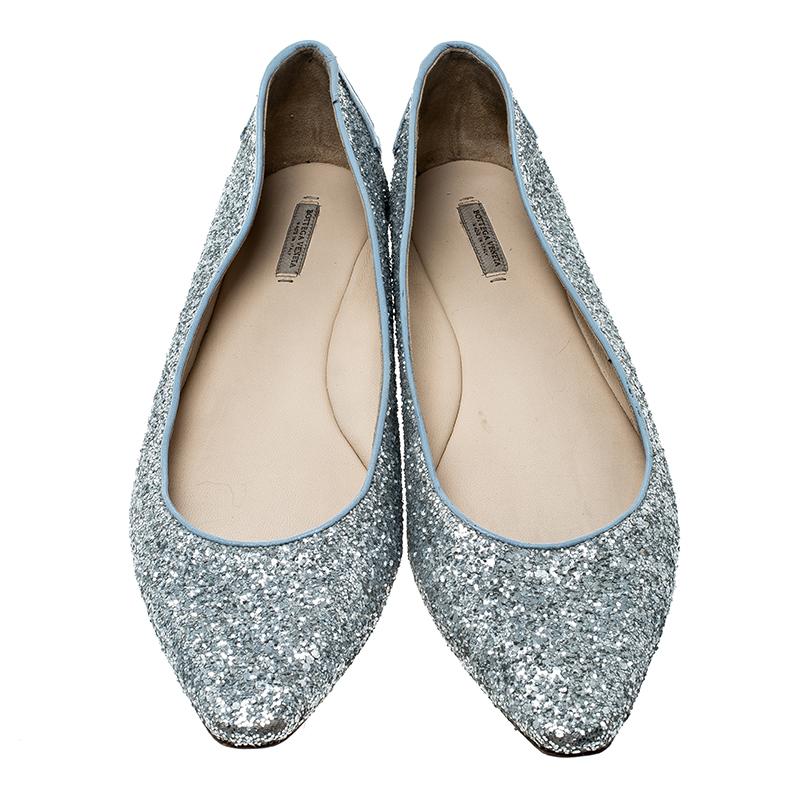 Shine in comfort and style with these ballet flats from Bottega Veneta! They've been lovingly covered in silver glitter and designed with pointed toes and intrecciato leather trims on the counters. You will surely dazzle in this pair.

Includes: The