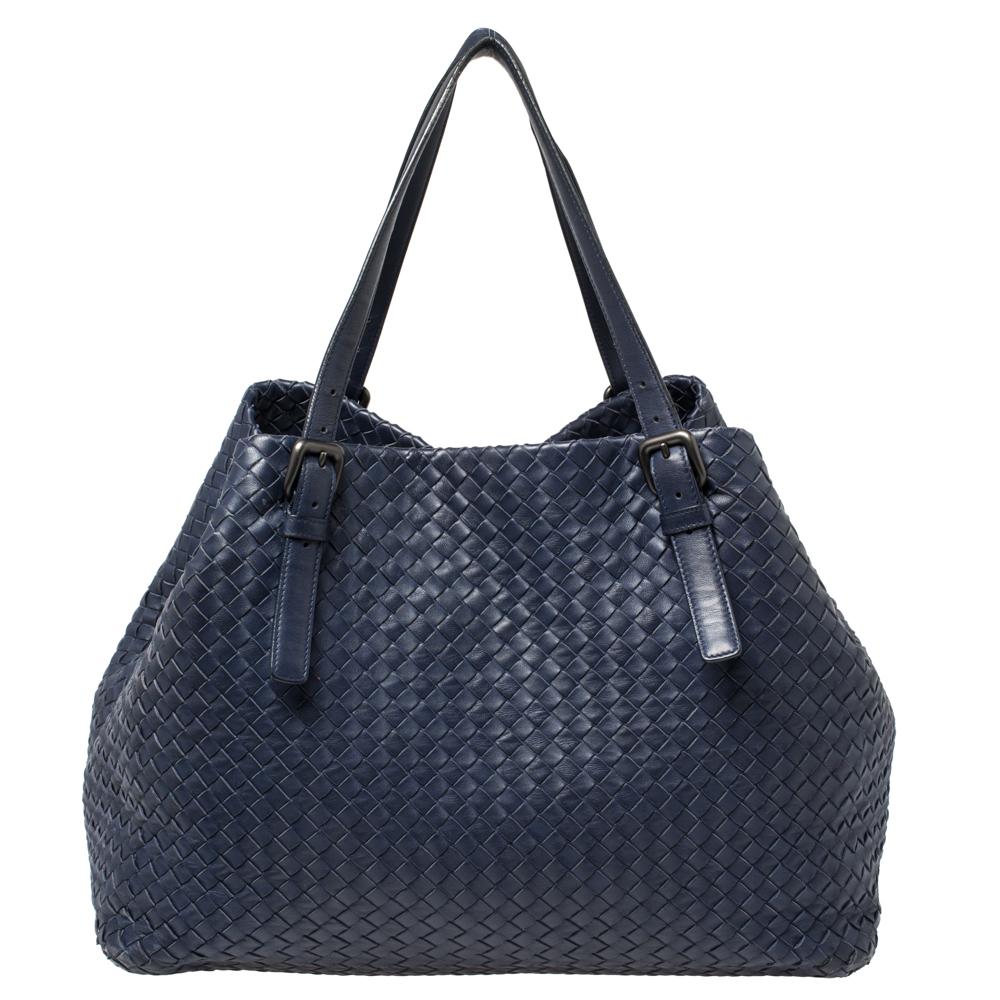 Bottega Veneta's Cesta tote is made for a modern woman like you. Woven from leather in their signature Intrecciato technique, it features a midnight blue shade and a capacious interior for your belongings. The bag suspends from dual handles so that