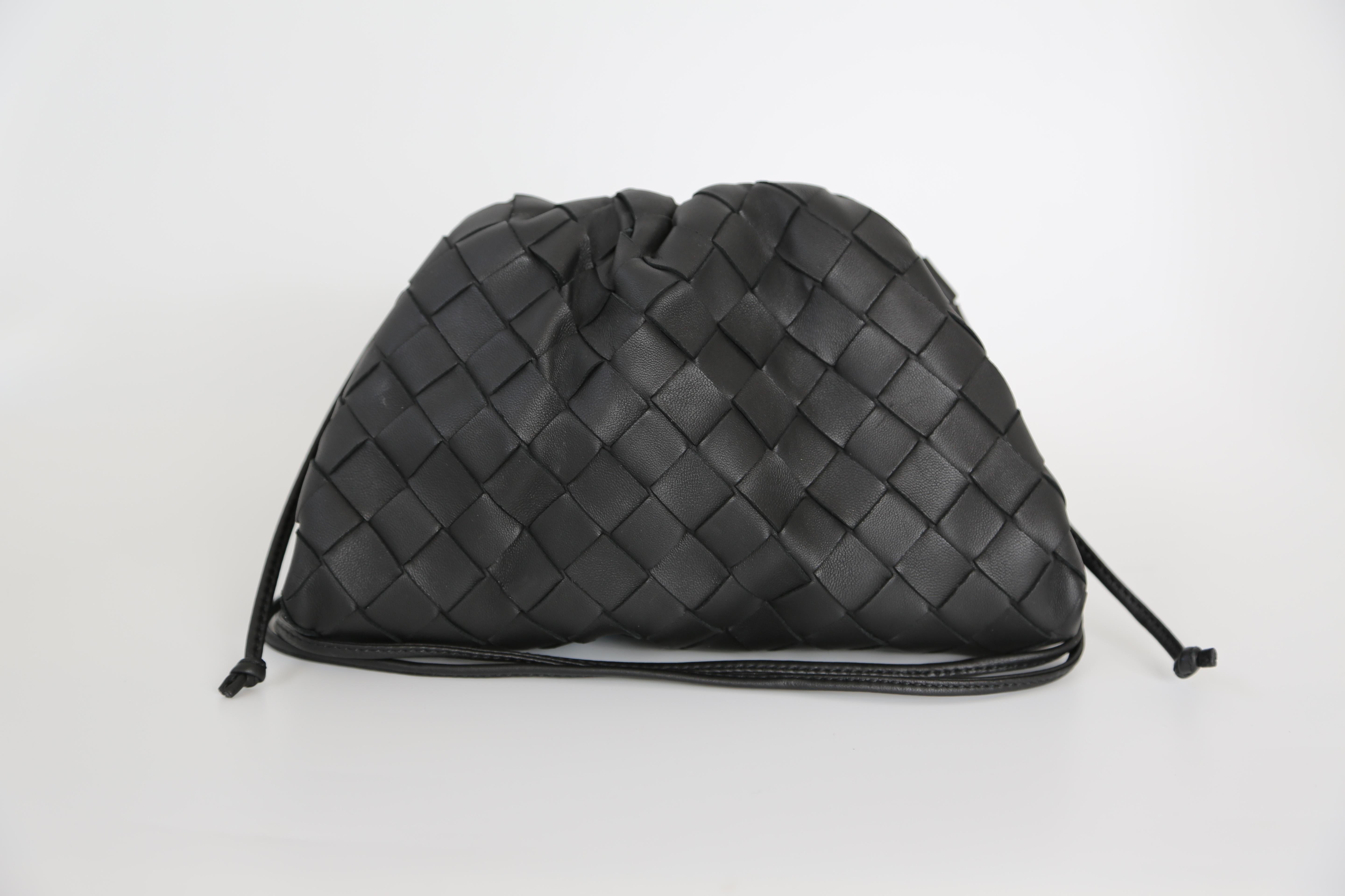 Bottega Veneta showcases their signature Intrecciato weaving, a technique that was created by Bottega Veneta in the late 1960s and involves strips of leather that are intertwined to create a woven pattern. The bag comes with a strap and is in