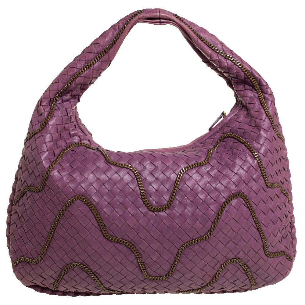 The excellent craftsmanship of this Bottega Veneta hobo ensures a brilliant finish and a rich appeal. Woven from leather in their signature Intrecciato pattern, the fuchsia-hued bag is provided with chain detailing all over. It features a loop