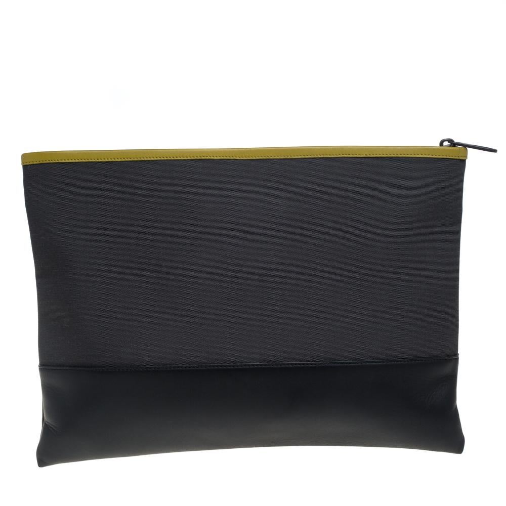 This clutch from Bottega Veneta is made from quality canvas and leather in Italy. It has a convenient intrecciato pocket at the front and a leather-lined interior that is secured by a zip closure. This clutch has a smart shape.

Includes: Original