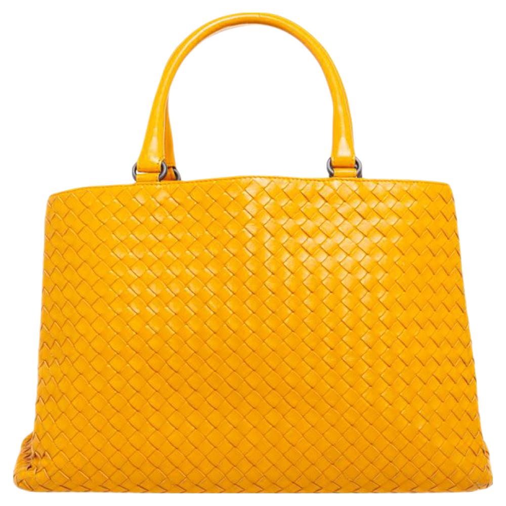 This beautiful mustard tote from Bottega Veneta is spacious. Crafted from leather, it features double top handles and an interior lined with suede. The exterior of the bag carries the famous Intrecciato pattern that is unique to the fashion house.