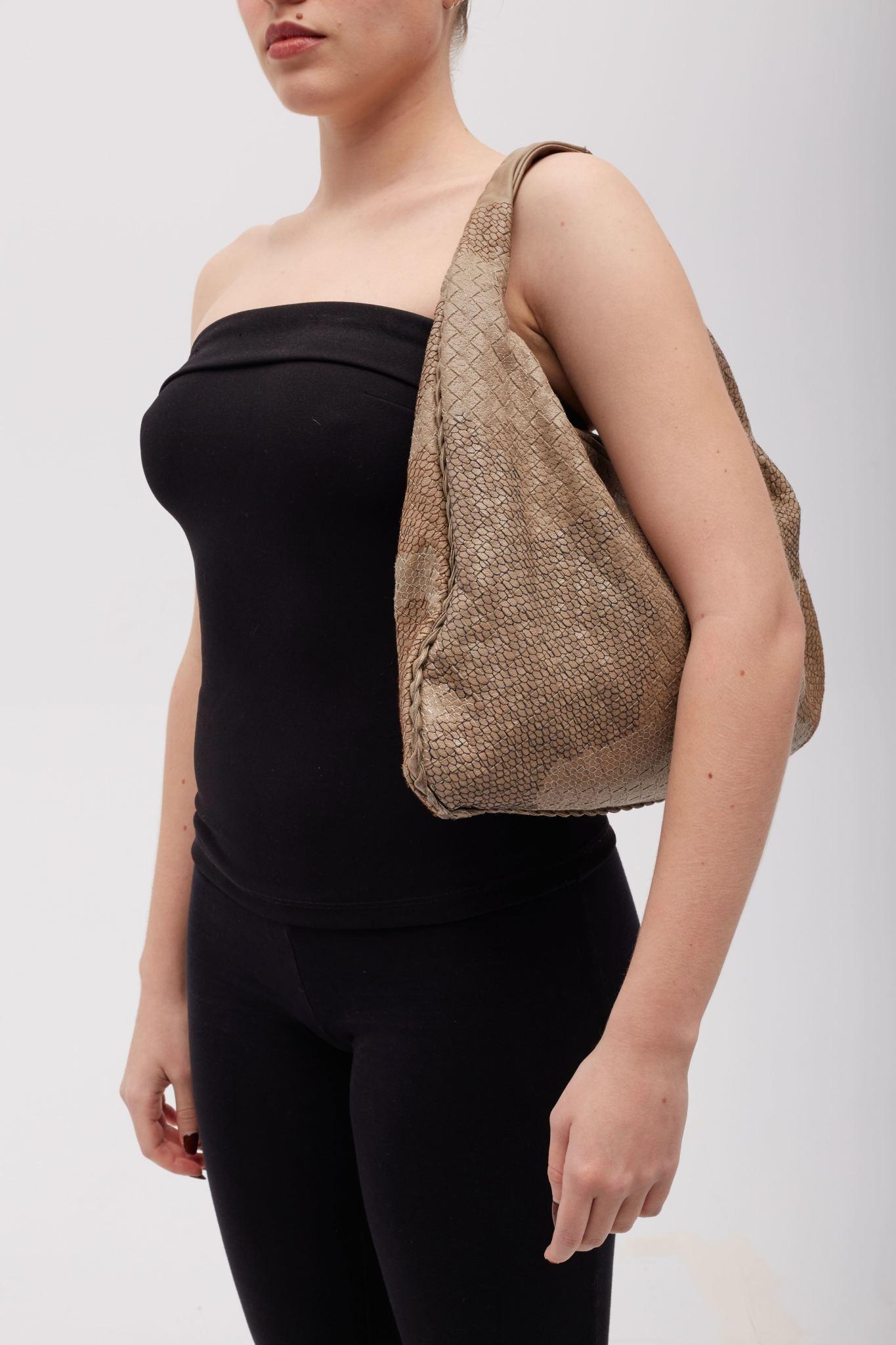 Designed by Tomas Maier. This is hobo bag that is constructed of embroidered intrecciato tightly woven luxurious Nappa calfskin leather dyed in a multi-hued camo print. The bag is finished with embroidery resembling snake skin. The top has a silver