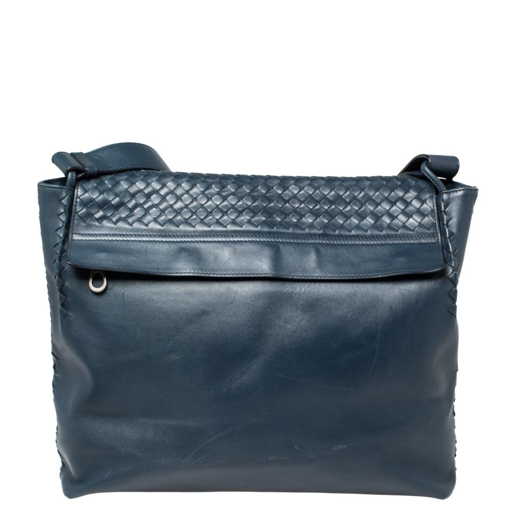 This messenger bag from Bottega Veneta is what your wardrobe has been missing all this while! This navy blue bag is crafted from leather in the signature Intrecciato pattern and features an adjustable shoulder strap. The bag opens to a fabric-lined