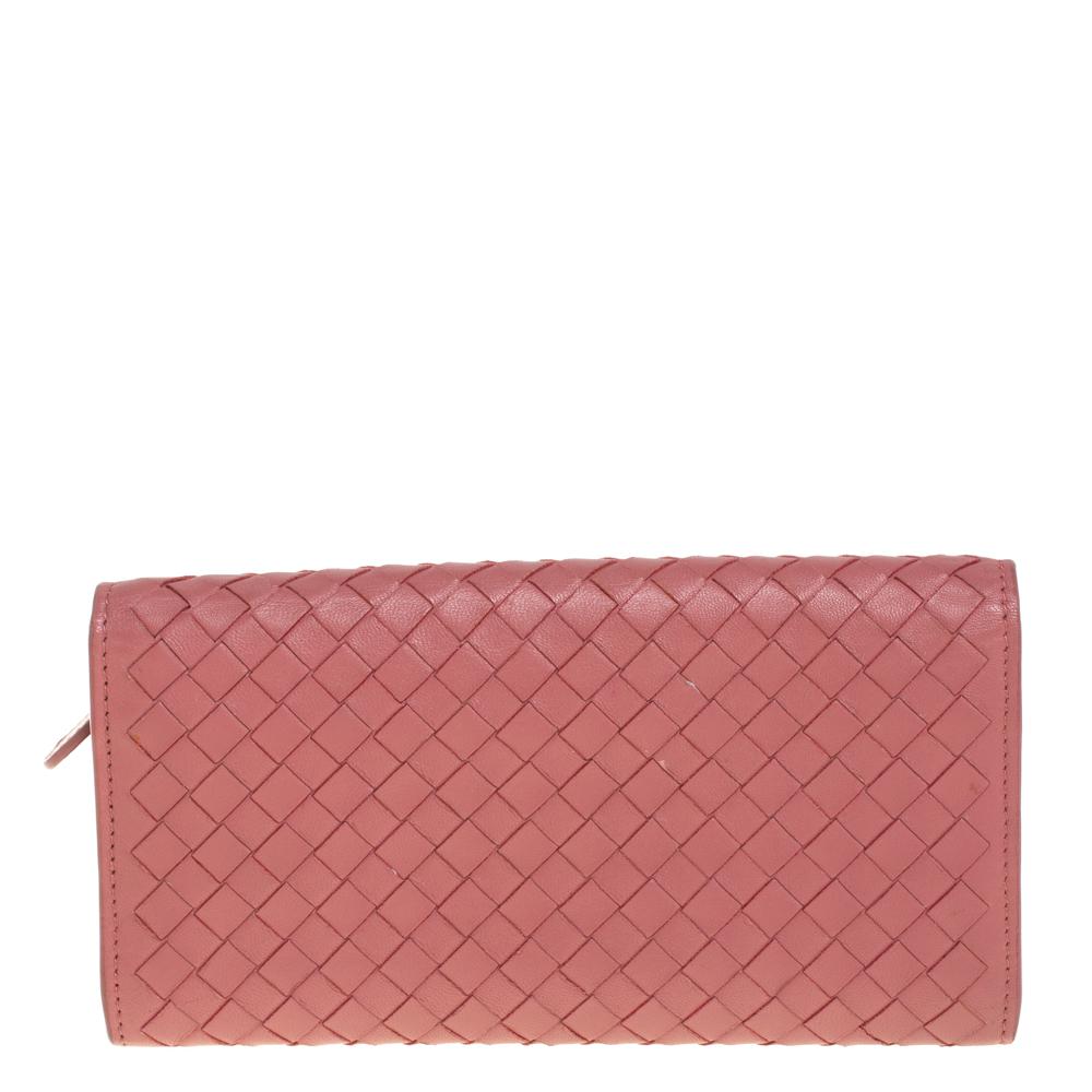 Covered in Bottega Veneta’s iconic Intrecciato weave, this old rose wallet is instantly recognizable. A front flap closes securely with a snap lock. The wallet opens to show open compartments, a zipped pocket, and multiple card slots.

