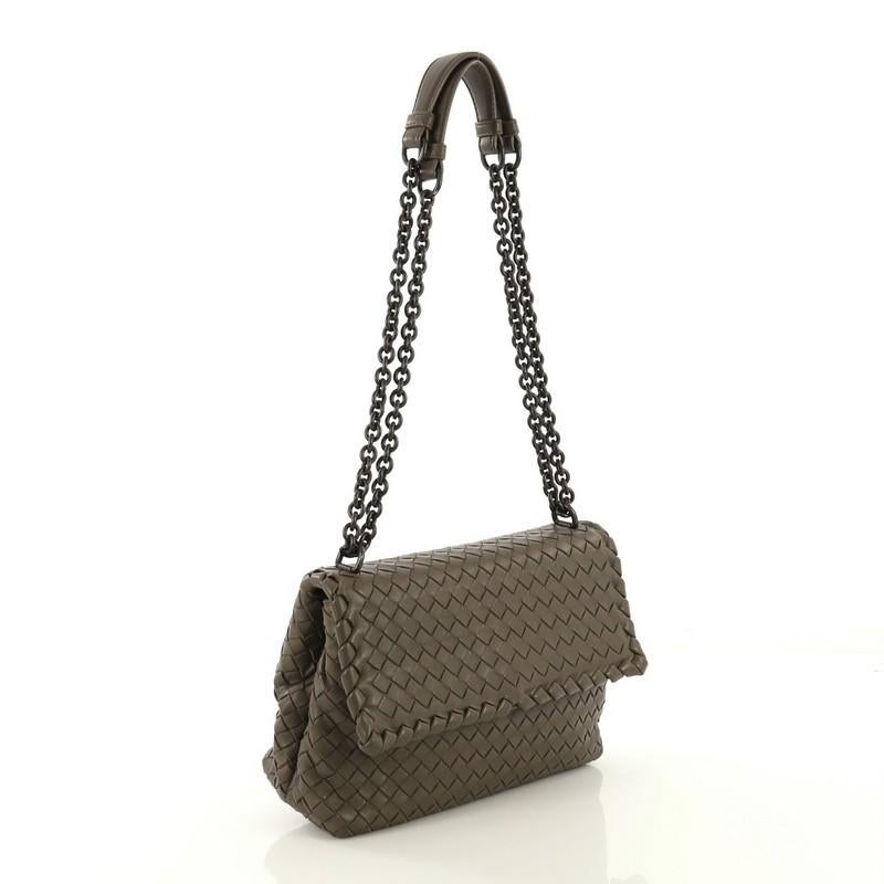This Bottega Veneta Olimpia Crossbody Bag Intrecciato Nappa Small, crafted from brown intrecciato nappa leather, features chain link straps with leather pads, frontal flap, and gunmetal-tone hardware. Its snap closure opens to a brown suede interior