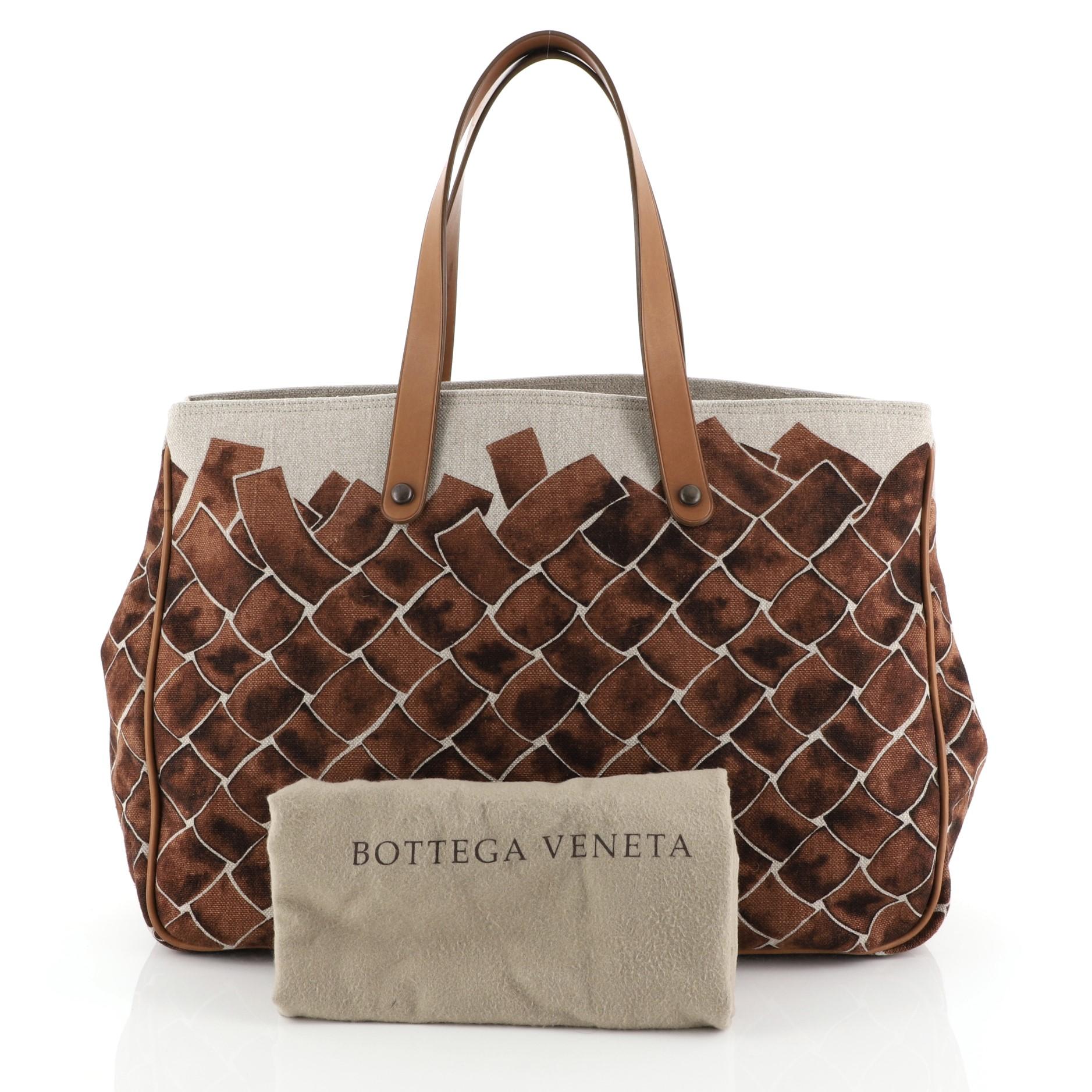 This Bottega Veneta Open Tote Printed Canvas Large, crafted from brown printed canvas, features flat leather straps, leather trim and bronze-tone hardware. It opens to a gray fabric interior.

Condition: Very good. Minor wear on base corners, scuffs