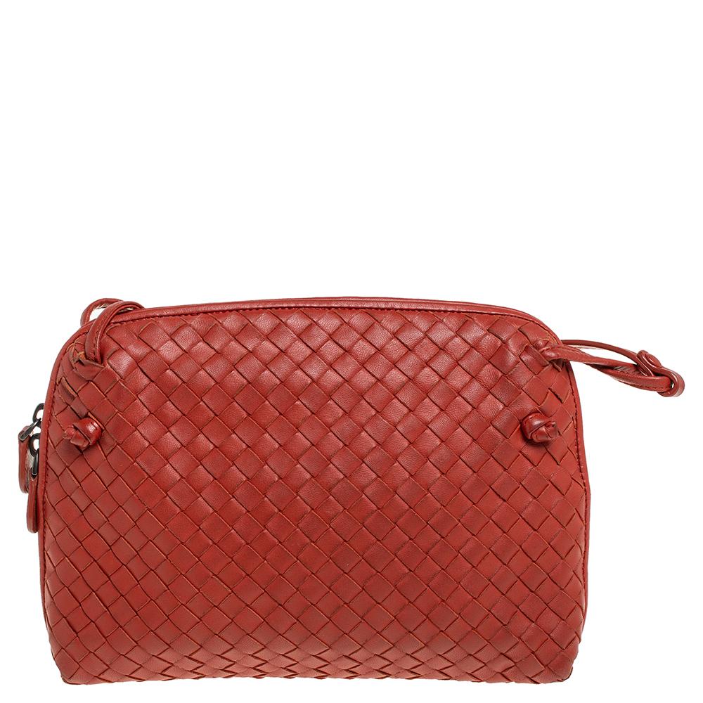 This Nodini bag from Bottega Veneta is crafted from orange leather using their signature Intrecciato weaving technique flaunting a seamless silhouette. This shoulder bag, personifying elegance and subtle charm, is held by a long shoulder strap.